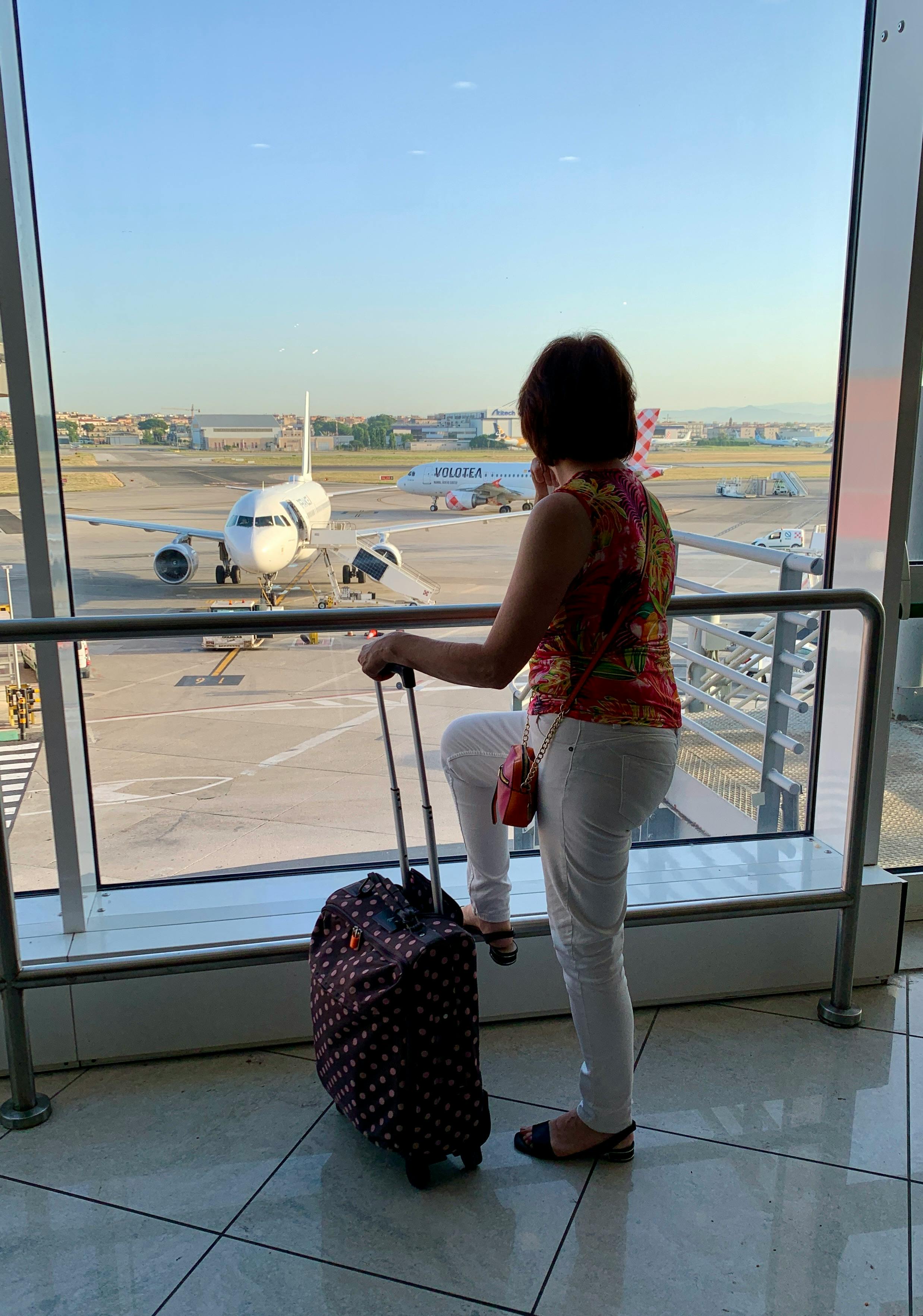 Mujer con equipaje esperando dentro de un aeropuerto | Fuente: Pexels