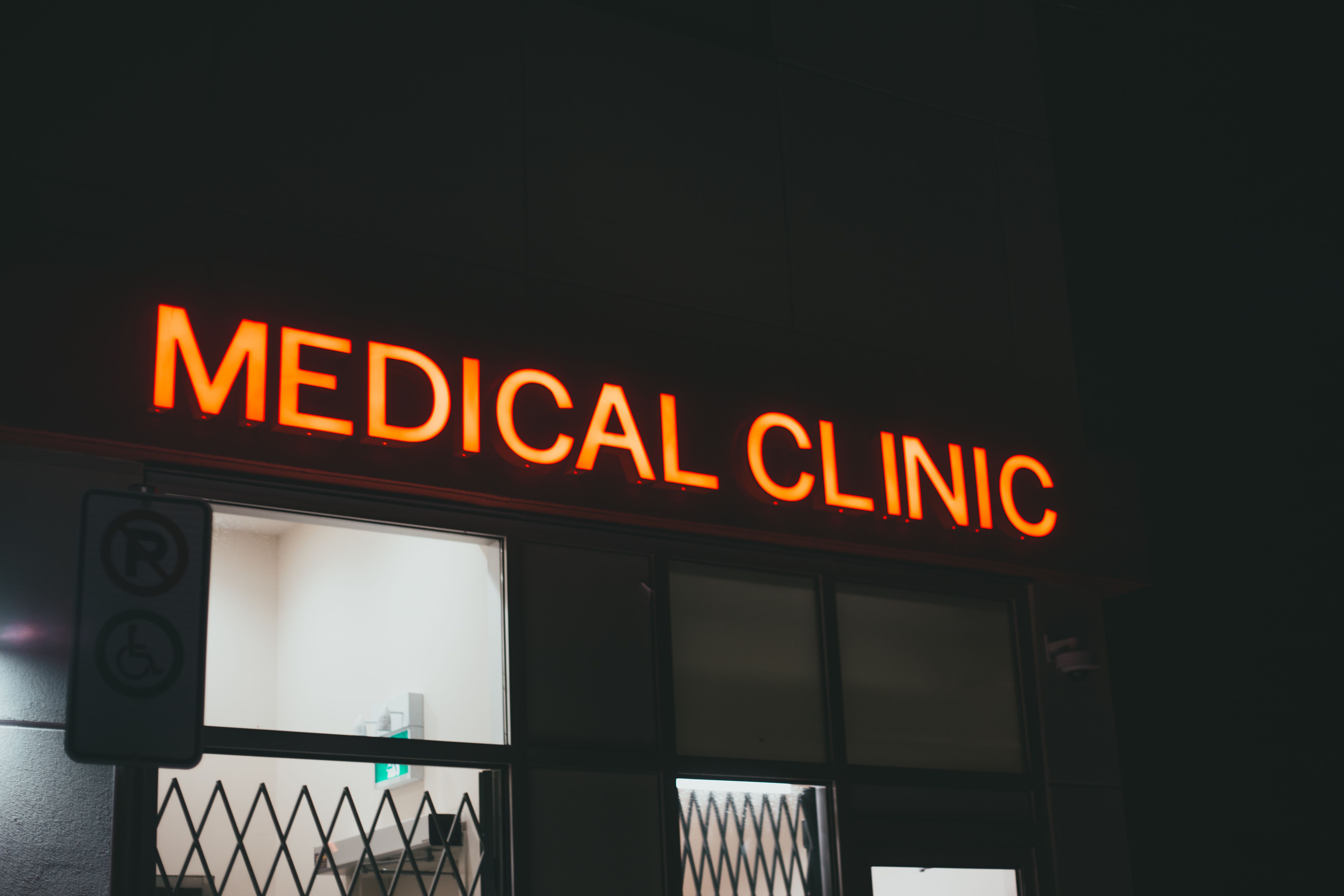 Un letrero de neón brillante de una clínica médica por la noche | Fuente: Pexels