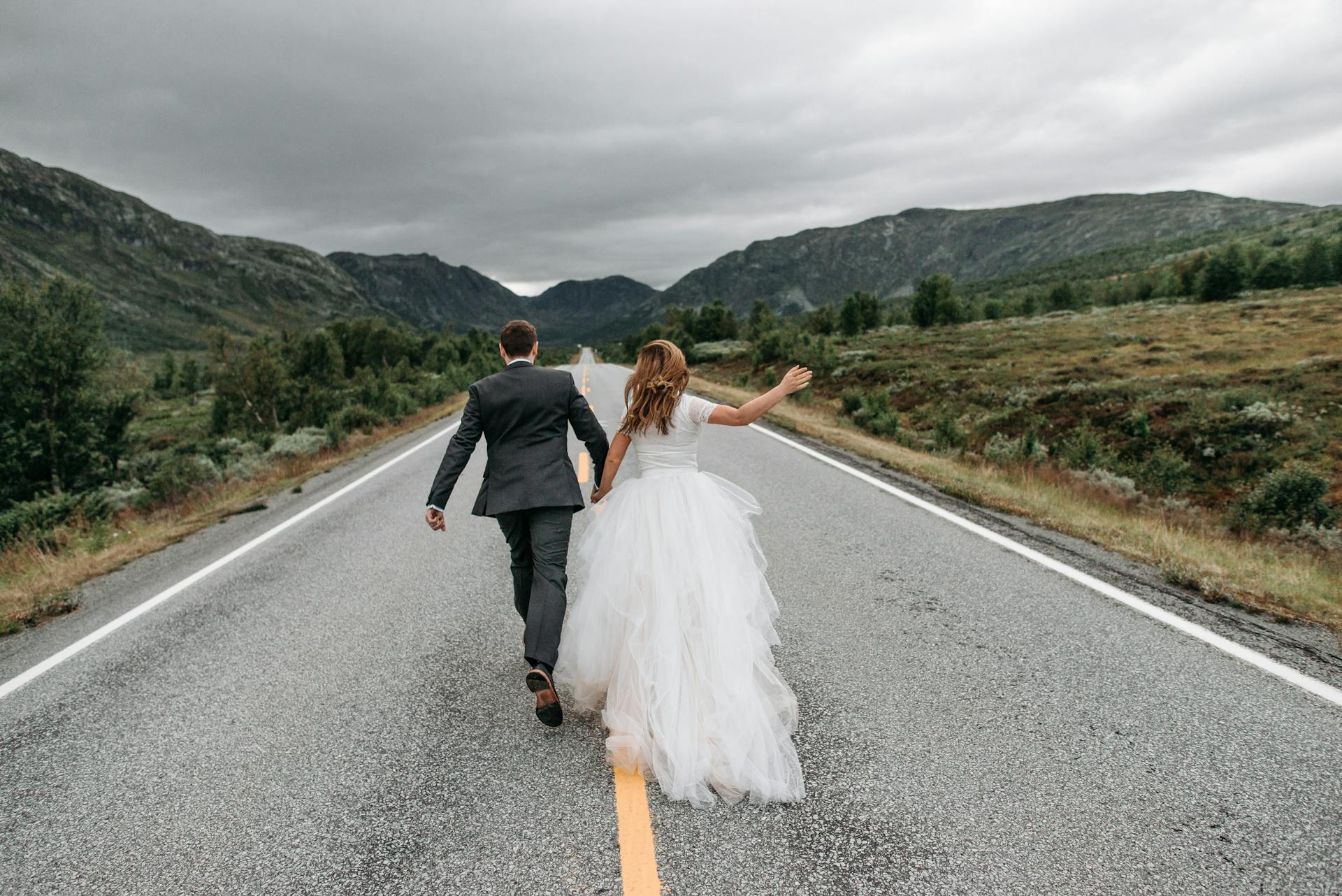 Unos novios corriendo por una carretera | Fuente: Pexels