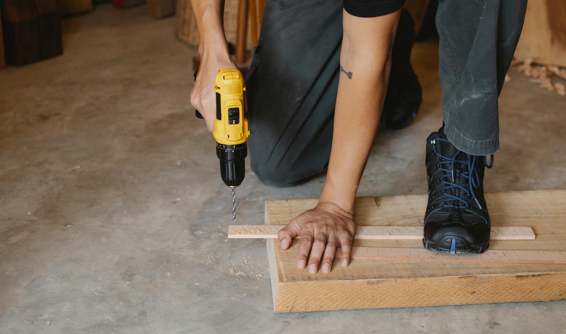 Un hombre taladra madera | Fuente: Pexels