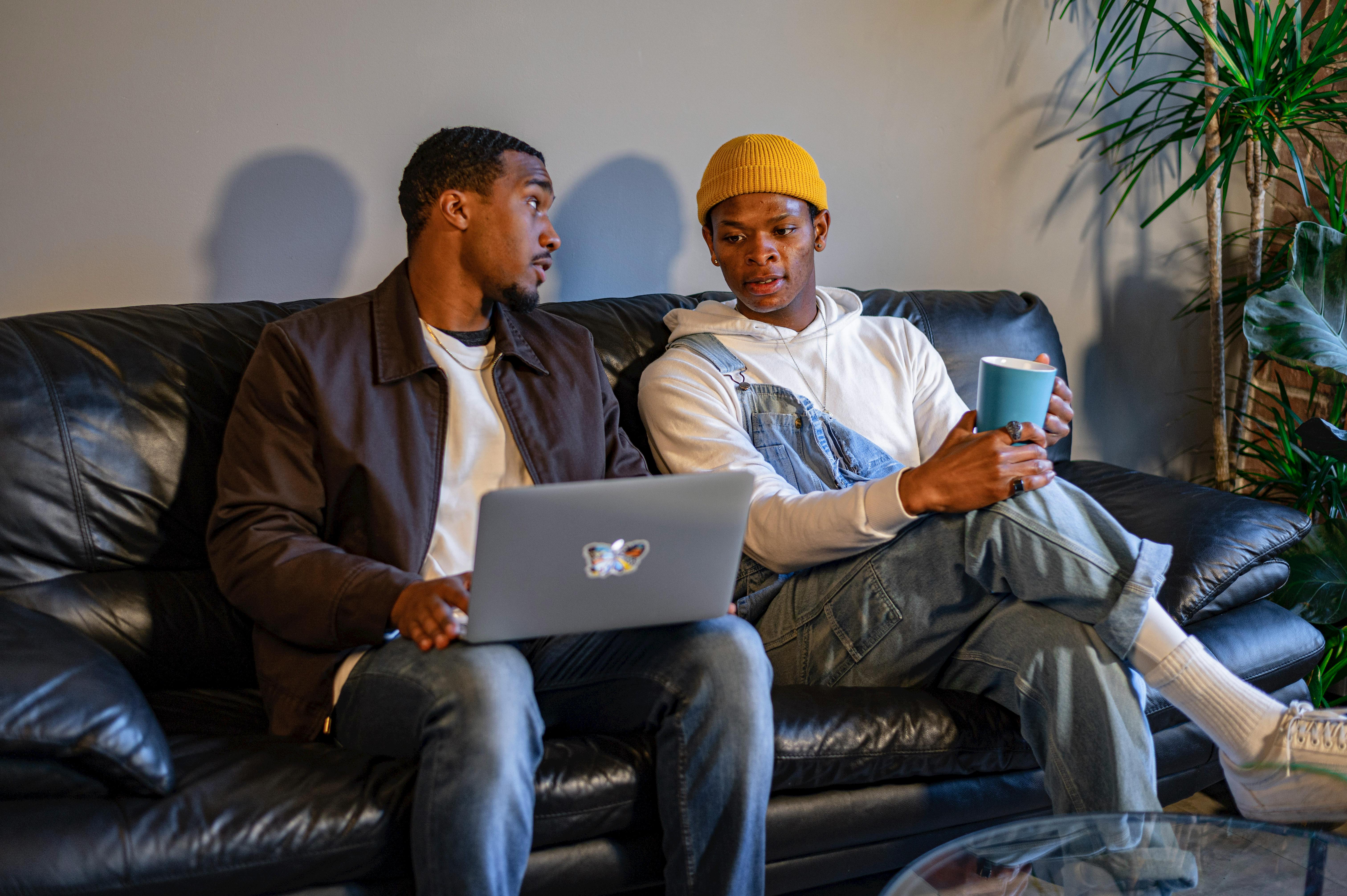 Hombres manteniendo una conversación sentados en un sofá | Foto: Pexels