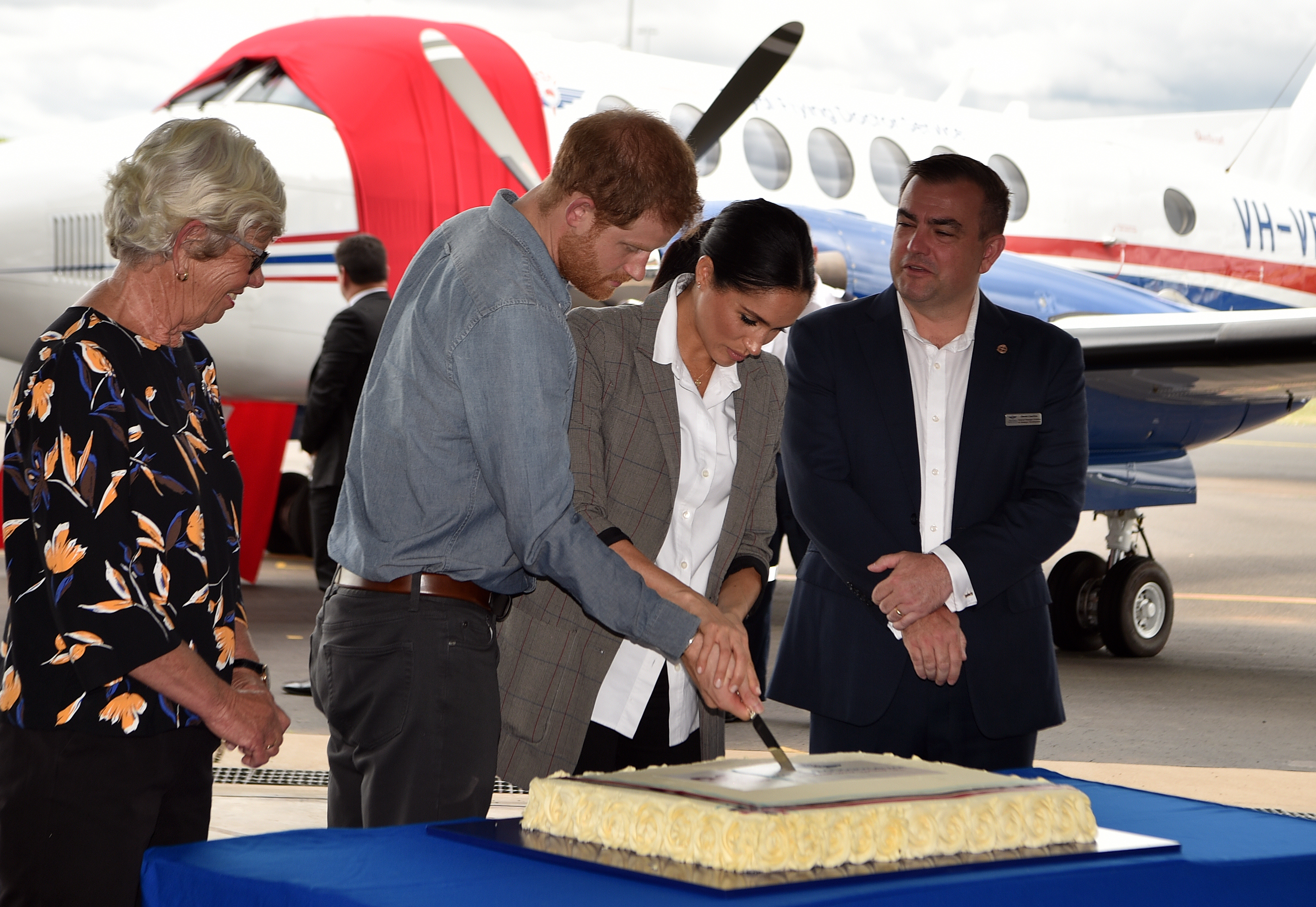 El príncipe Harry y Meghan Markle cortando un pastel de aniversario conmemorativo de los 90 años del Servicio Real de Médicos Voladores de Australia en el Aeropuerto Regional de Dubbo, Australia, el 17 de octubre de 2018 | Fuente: Getty Images