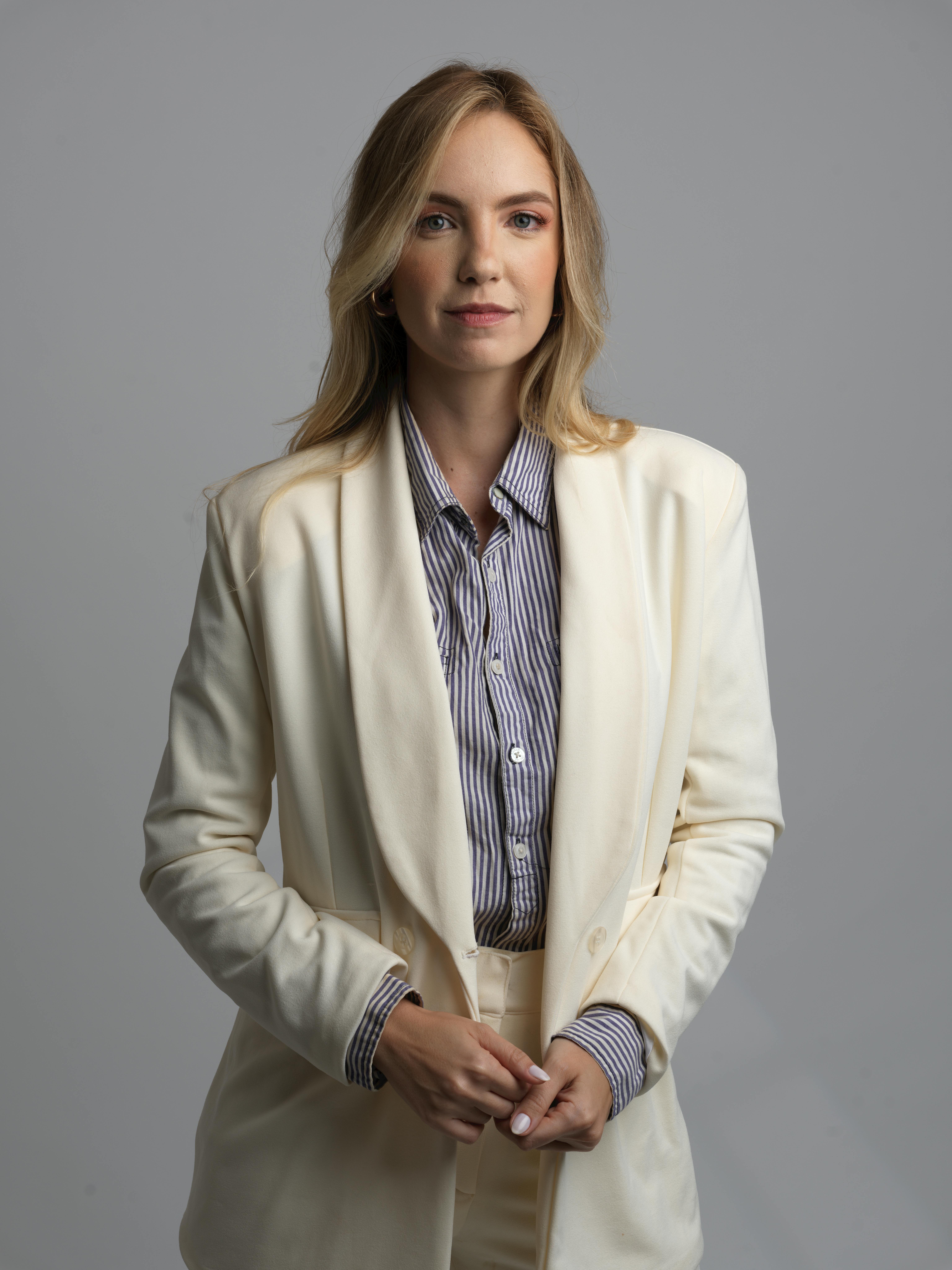 Una mujer feliz con traje | Fuente: Pexels