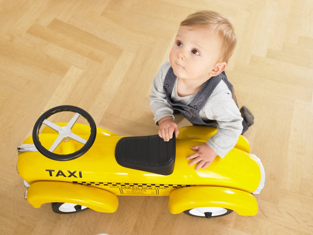 Bebé y taxi de juguete || Fuente: Shutterstock