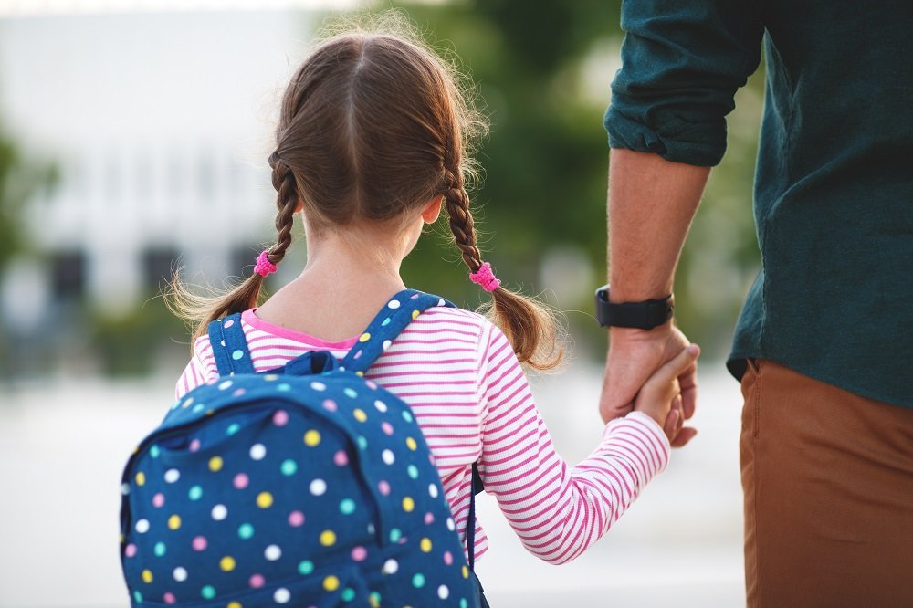 Niña con coletas entrando al colegio. Fuente: Shutterstock