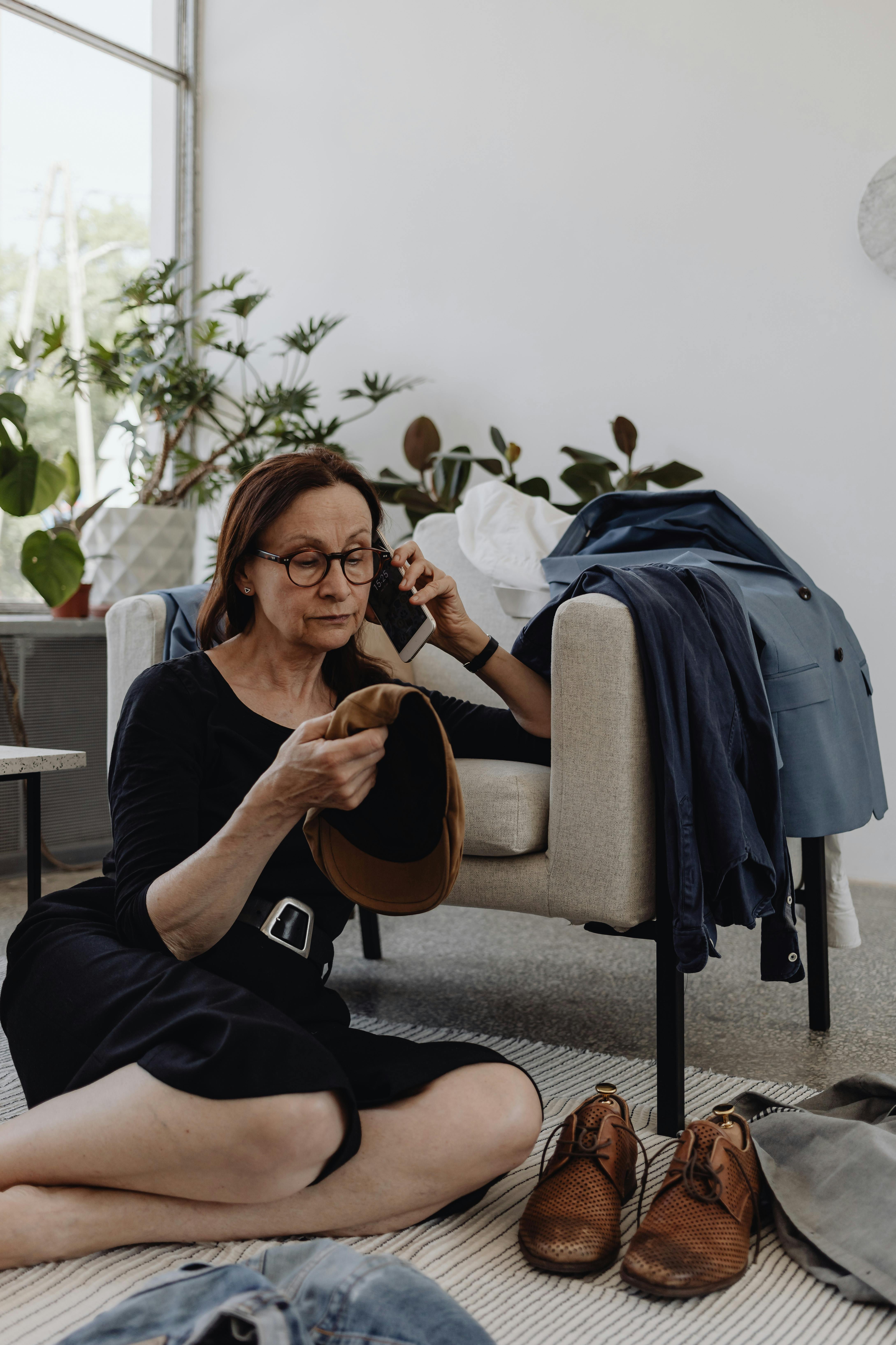 Una mujer con una gorra en la mano y hablando por teléfono | Fuente: Pexels