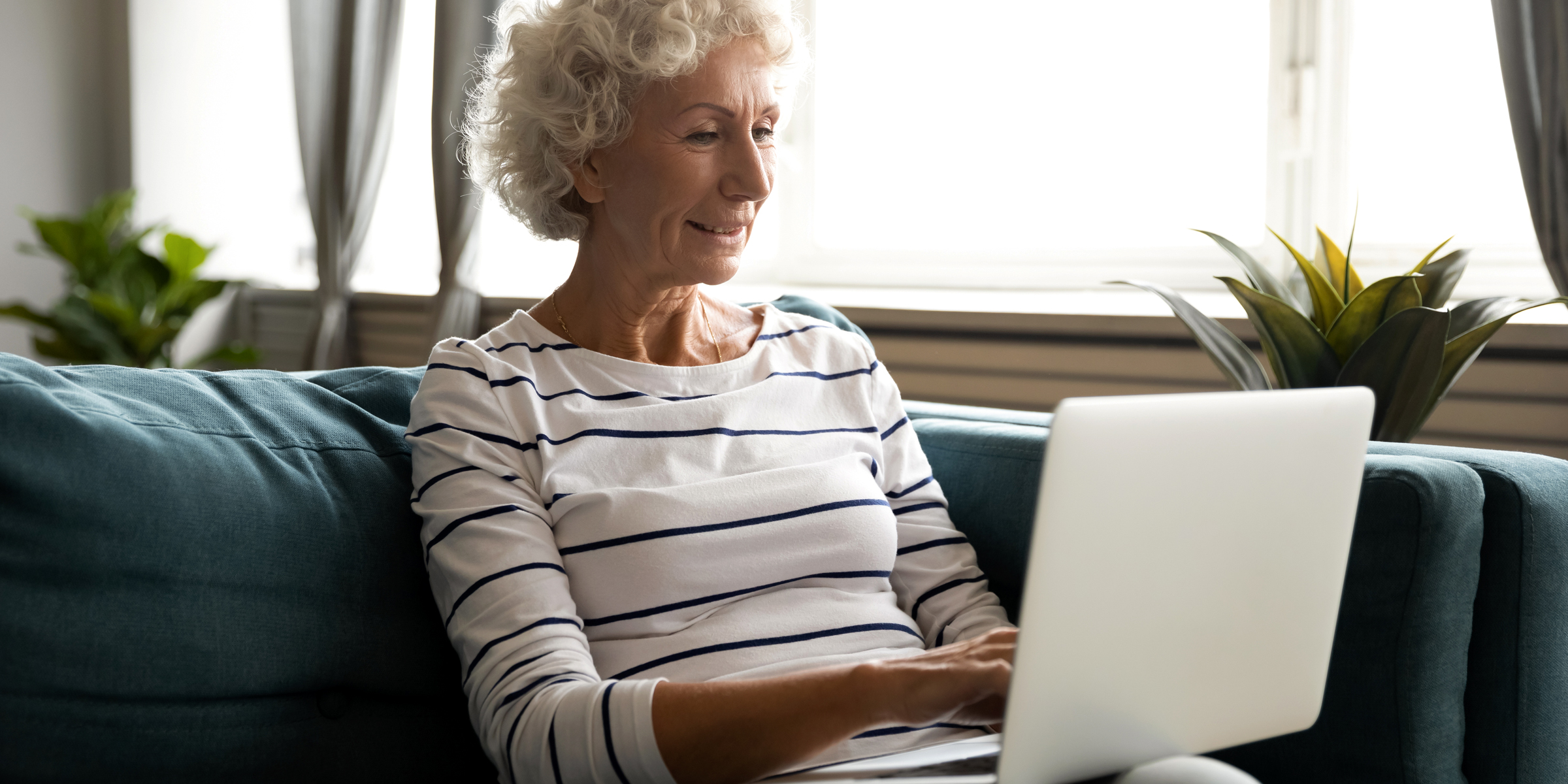 Anciana con su portátil | Fuente: Shutterstock