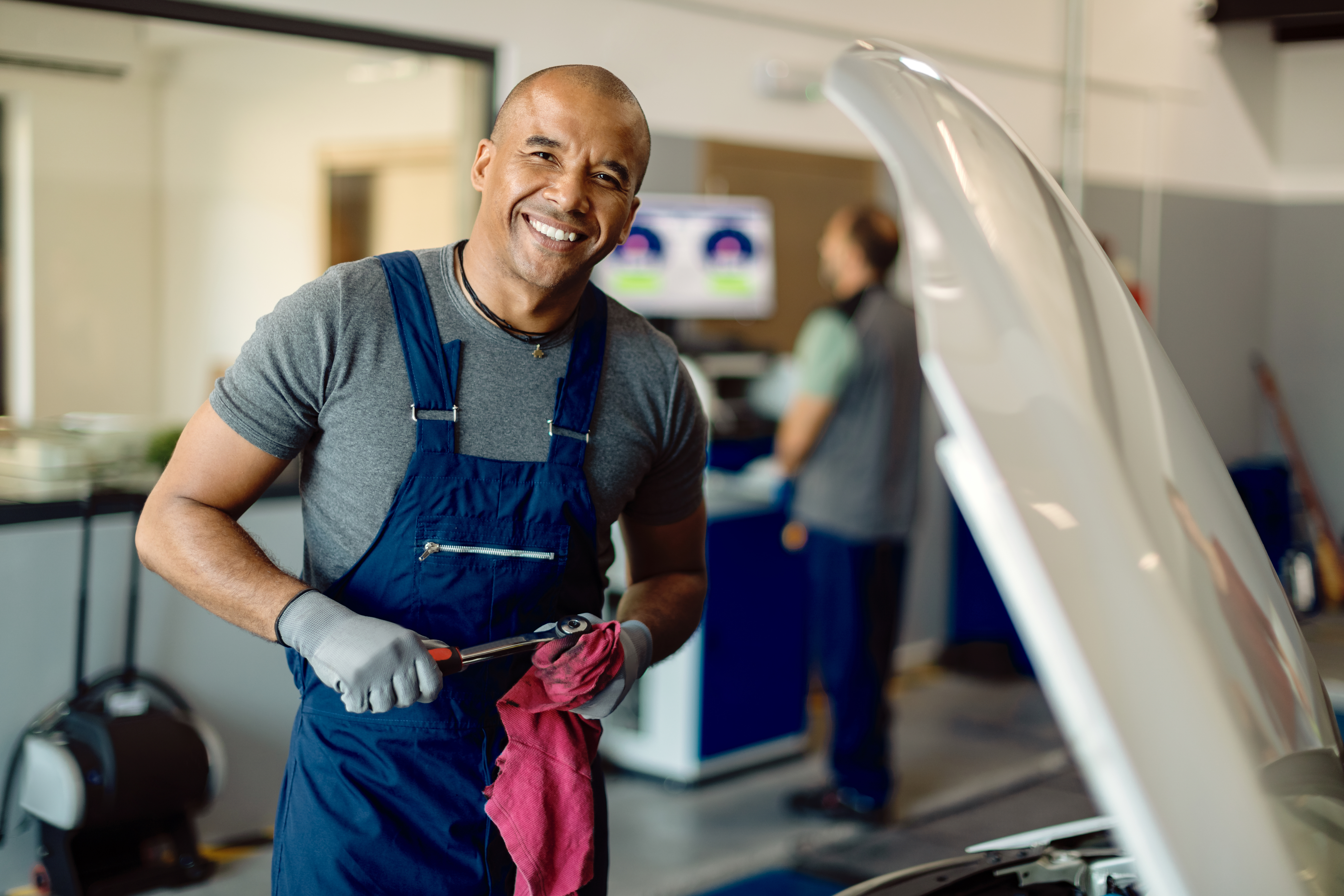 Un mecánico sonriendo en el trabajo | Fuente: FreePik