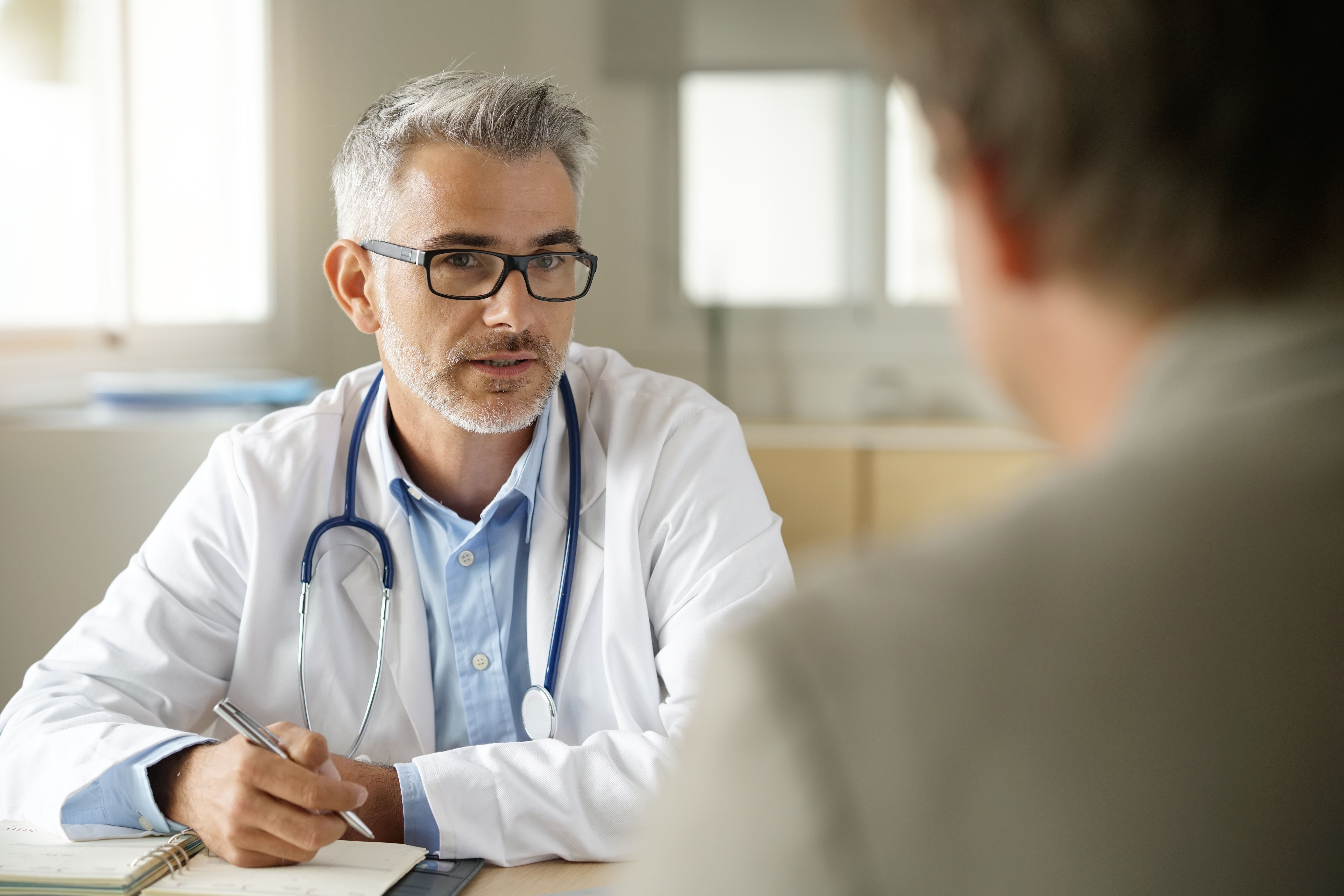 Médico hablando con un paciente | Fuente: Shutterstock