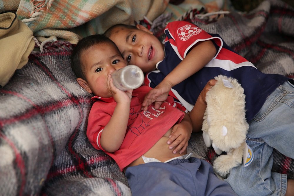 Niños sin hogar recostados sobre mantas. | Imagen: Flickr