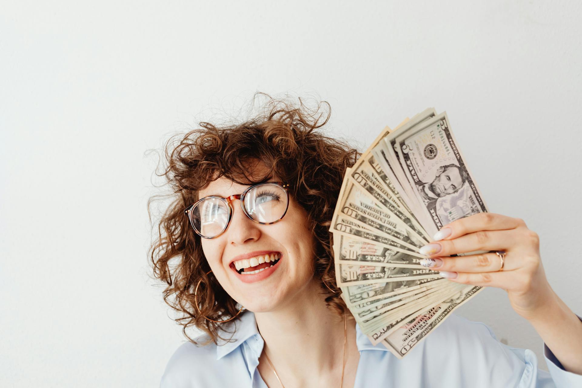 Una mujer mostrando su dinero en efectivo | Fuente: Pexels