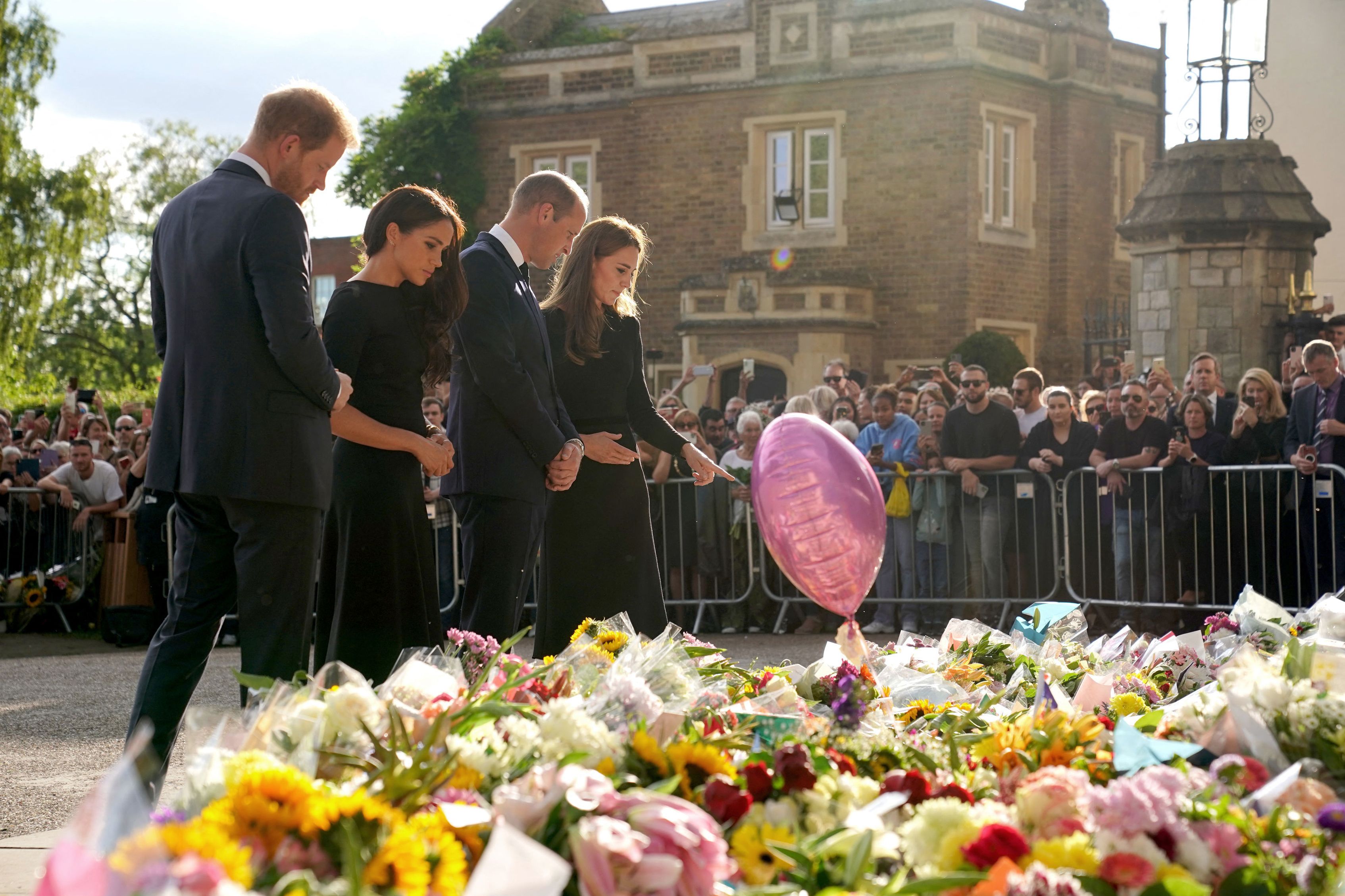El príncipe Harry , su esposa Meghan, el príncipe William y su esposa, Catherine, mirando los tributos florales colocados por el público en Long Walk en el castillo de Windsor, el 10 de septiembre de 2022. | Foto: Getty Images
