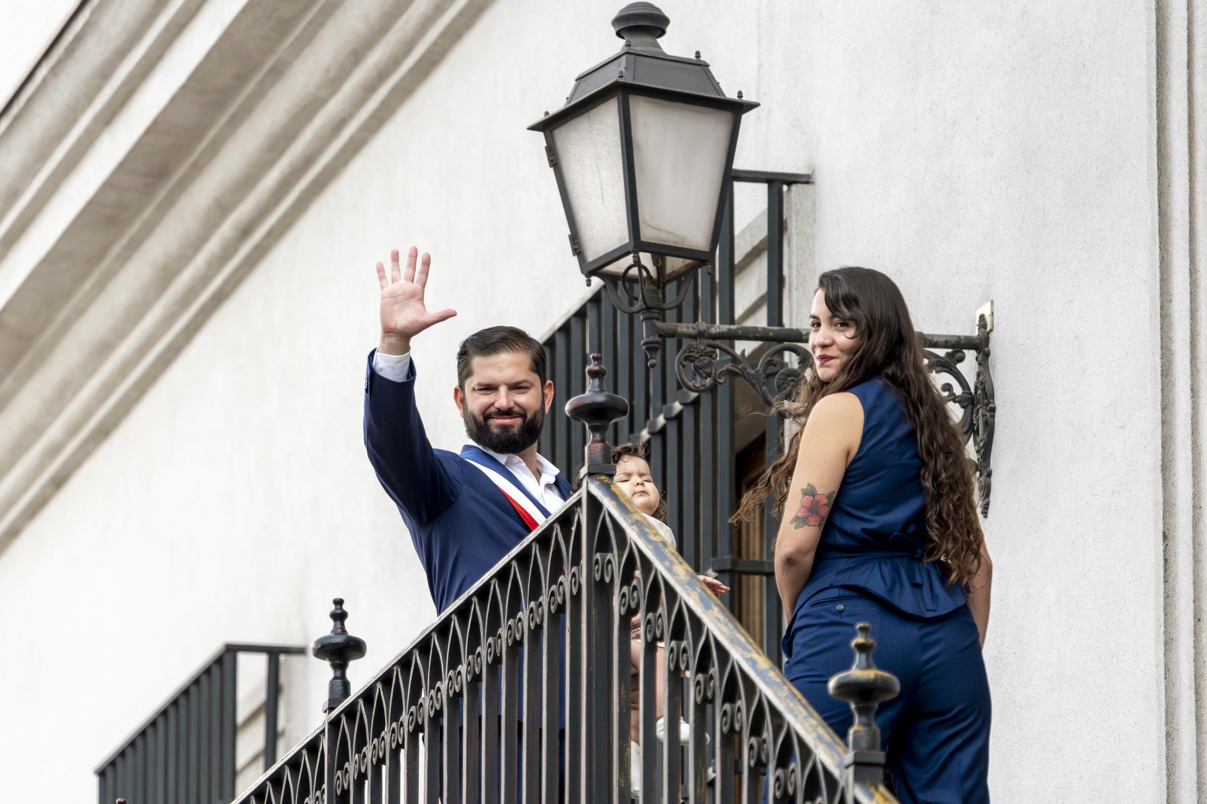 Gabriel Boric, junto a su hija Violeta y su pareja Paula Carrasco, saludan a la prensa desde el balcón de su despacho antes de abandonar el Palacio de La Moneda por última vez como presidente interino el 11 de marzo de 2026 en Santiago de Chile. | Fuente: Getty Images