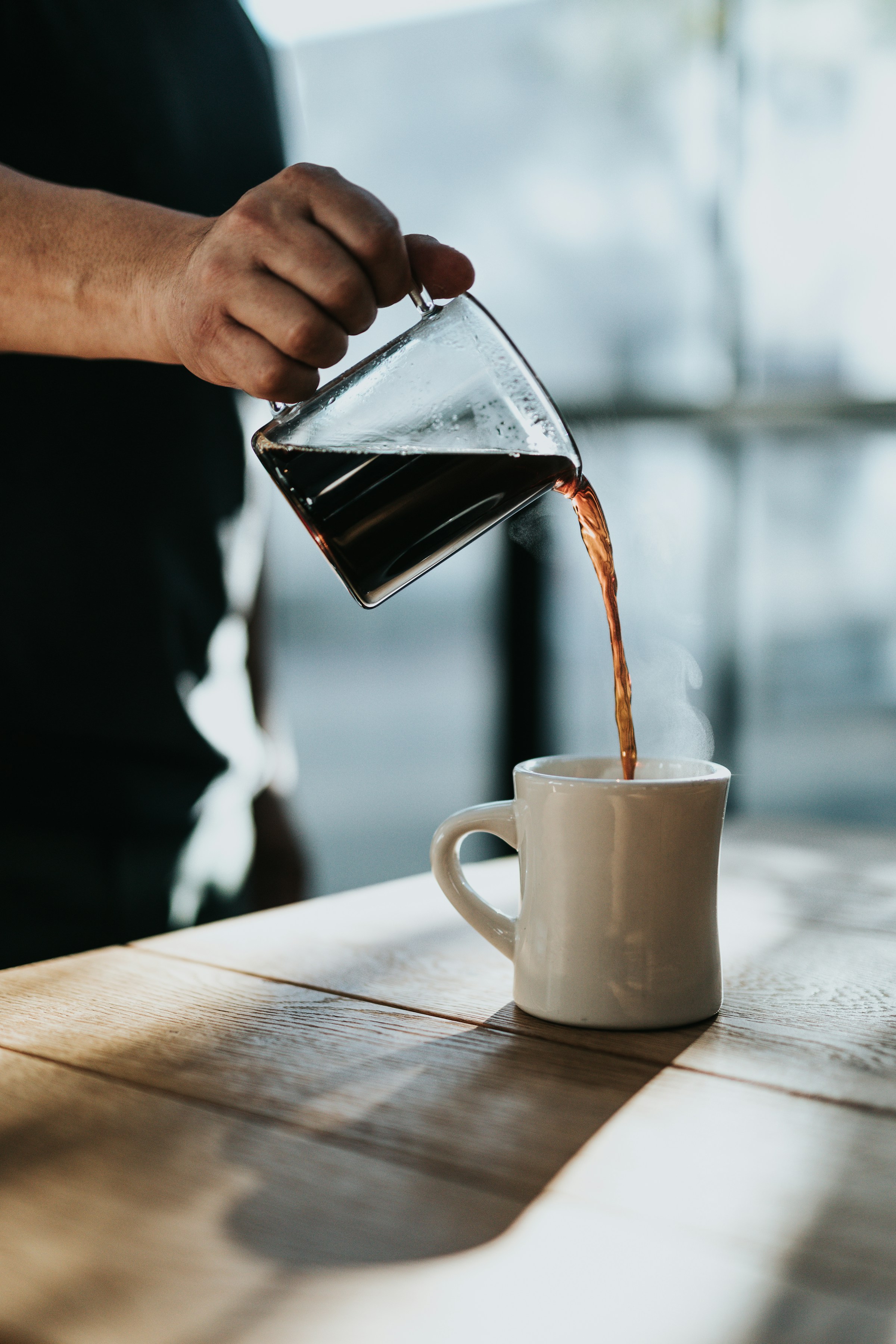 Persona vertiendo café en una taza | Foto: Unsplash