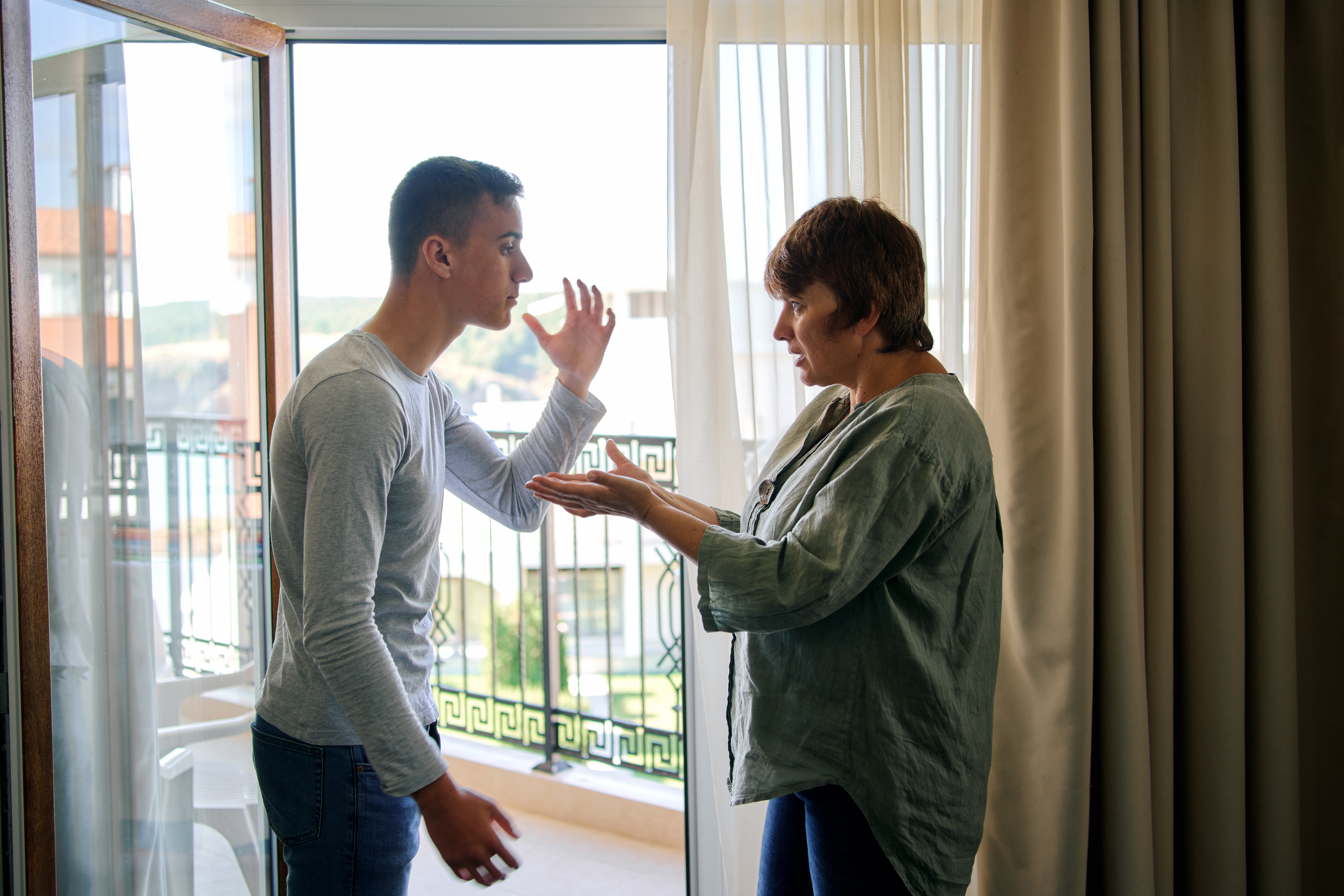 Un joven discutiendo con su madre | Fuente: Shutterstock