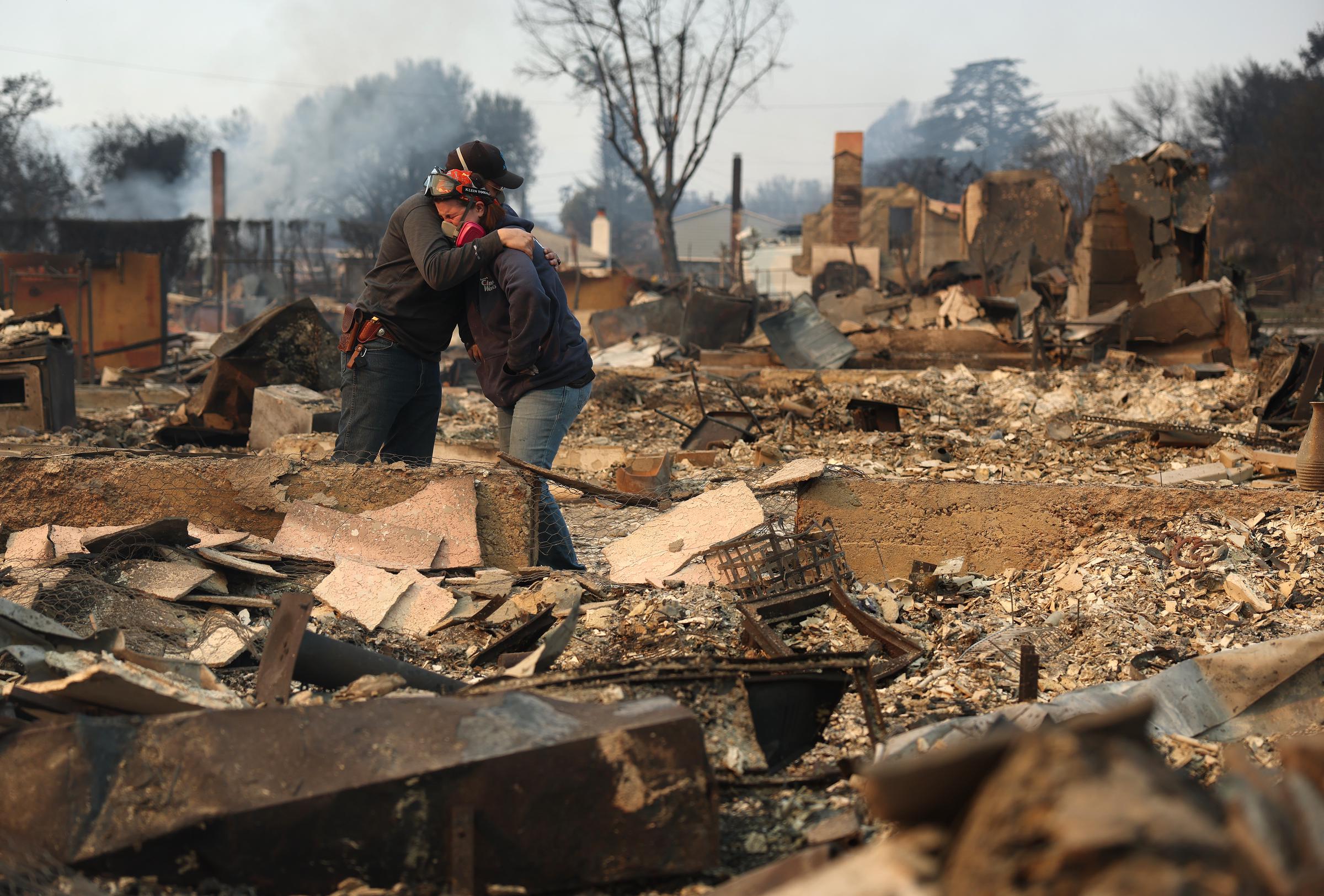 Khaled Fouad (I) y Mimi Laine (D) se abrazan mientras inspeccionan la propiedad de un familiar que fue destruida por el incendio Eaton el 09 de enero de 2025, en Altadena, California | Fuente: Getty Images