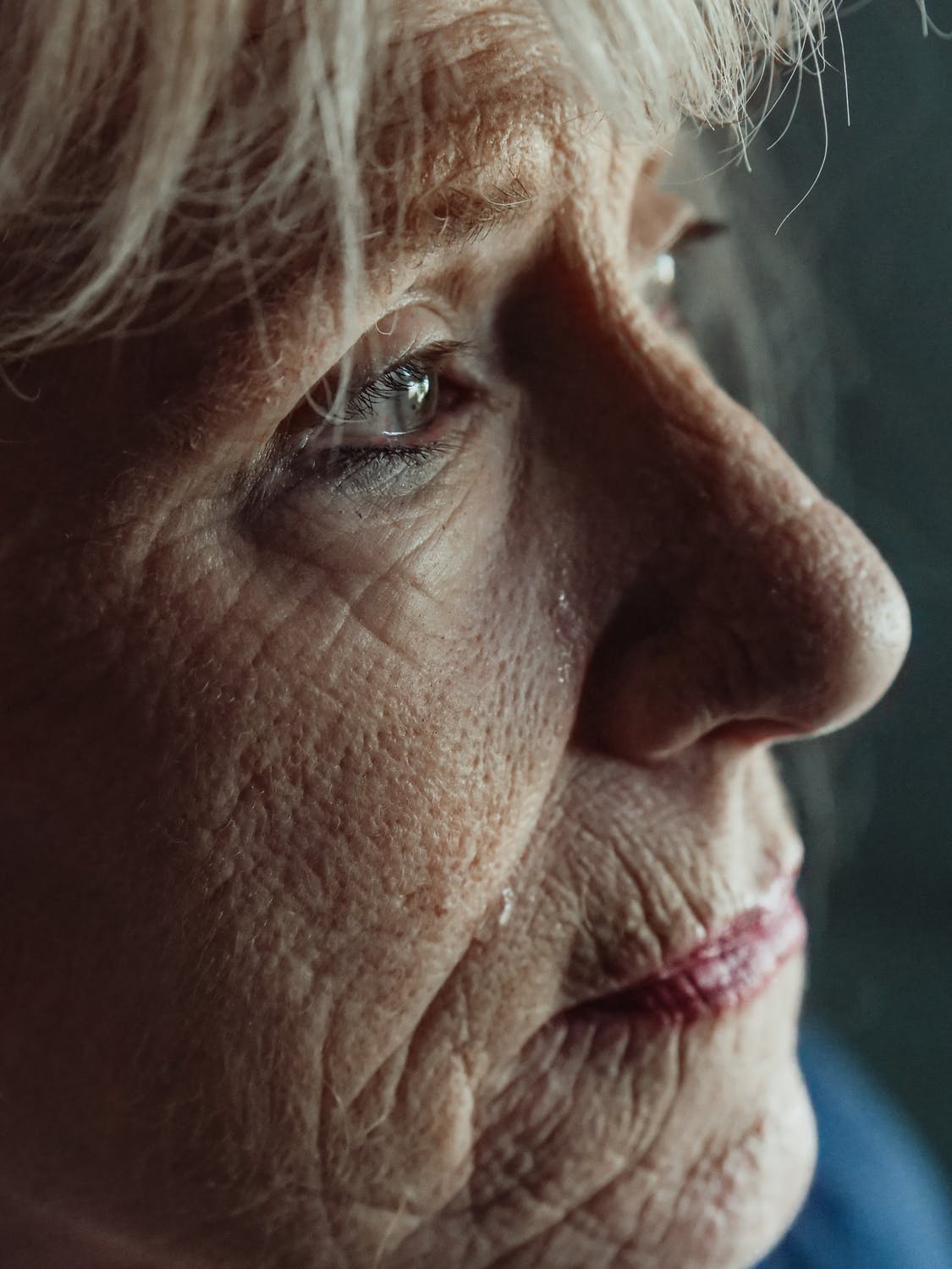 Anciana mirando hacia un lado con lágrimas en sus ojos. | Foto: Pexels