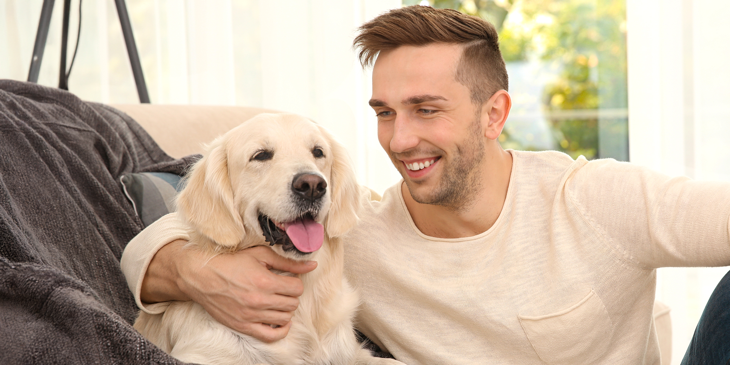 Un hombre abrazando a un perro | Fuente: Shutterstock