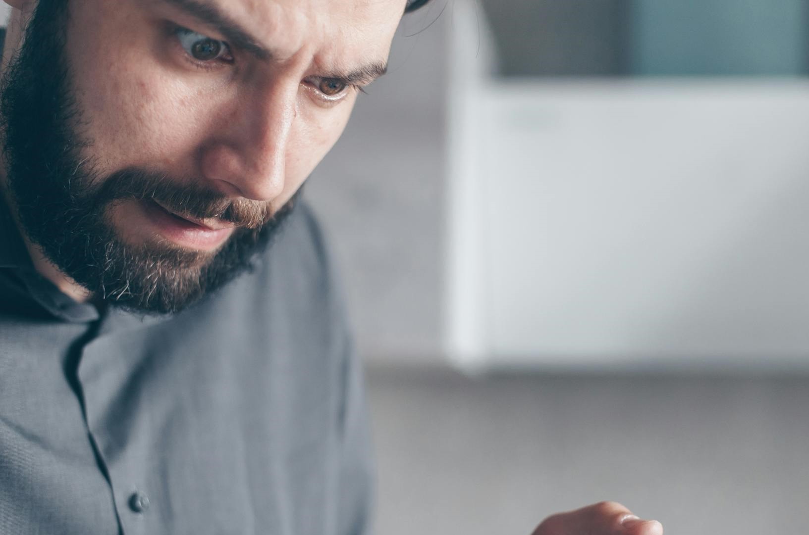 Un hombre conmocionado mirando hacia abajo | Fuente: Pexels