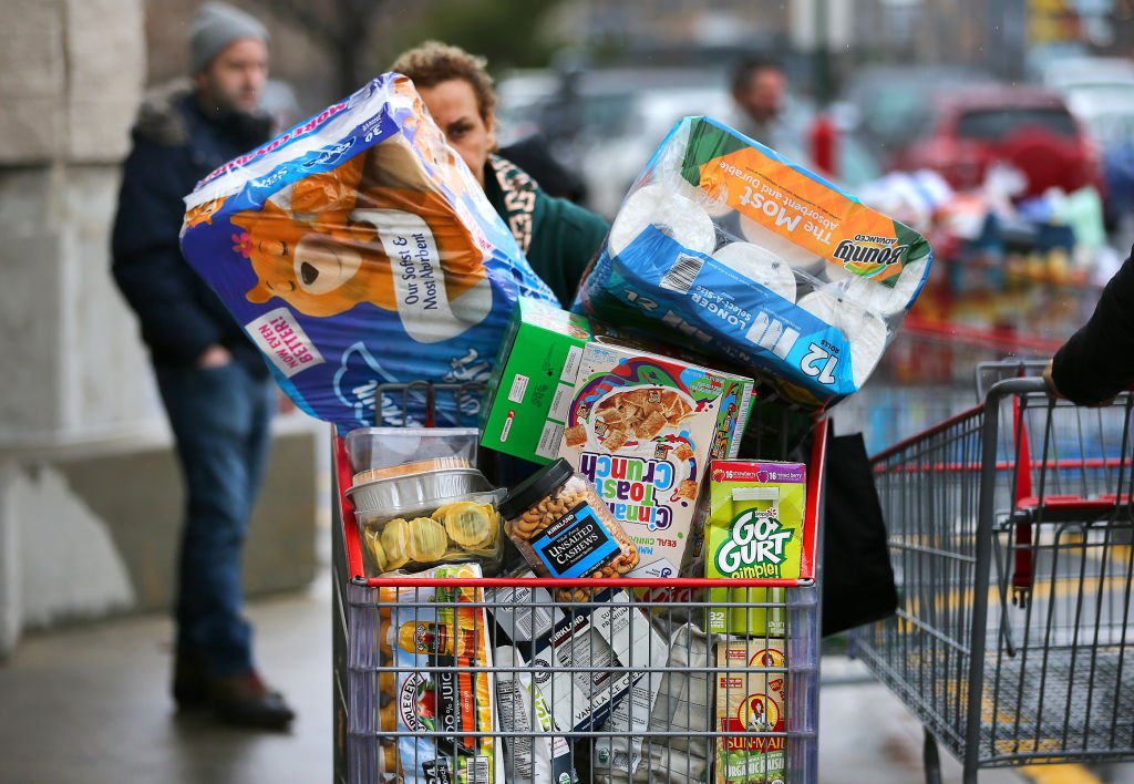 Compradores se abastecen de productos básicos como papel higiénico, agua embotellada, pañales y enlatados. | Foto de John Tlumacki a través de Getty Images