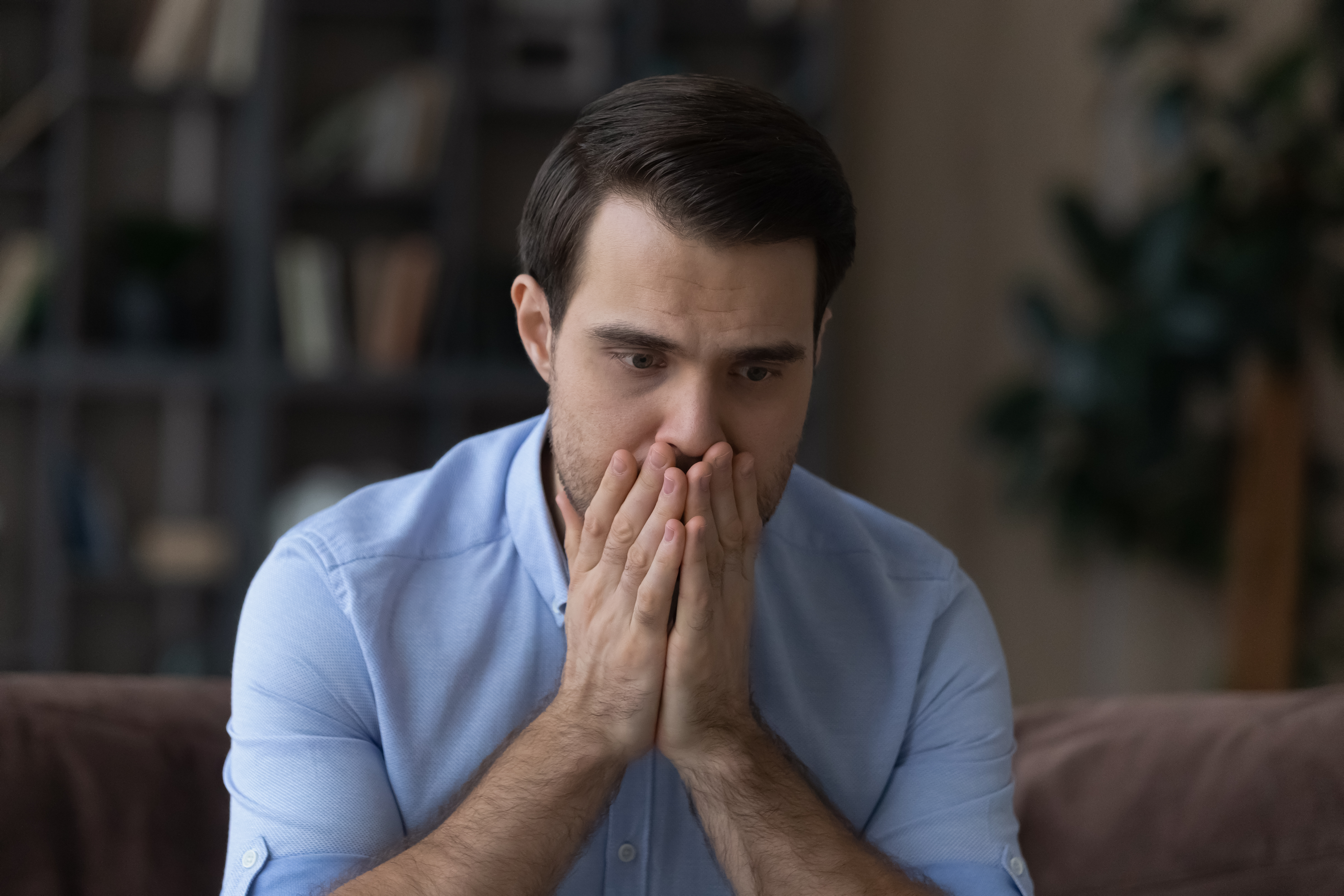 Un hombre tapándose la boca con las manos | Fuente: Shutterstock