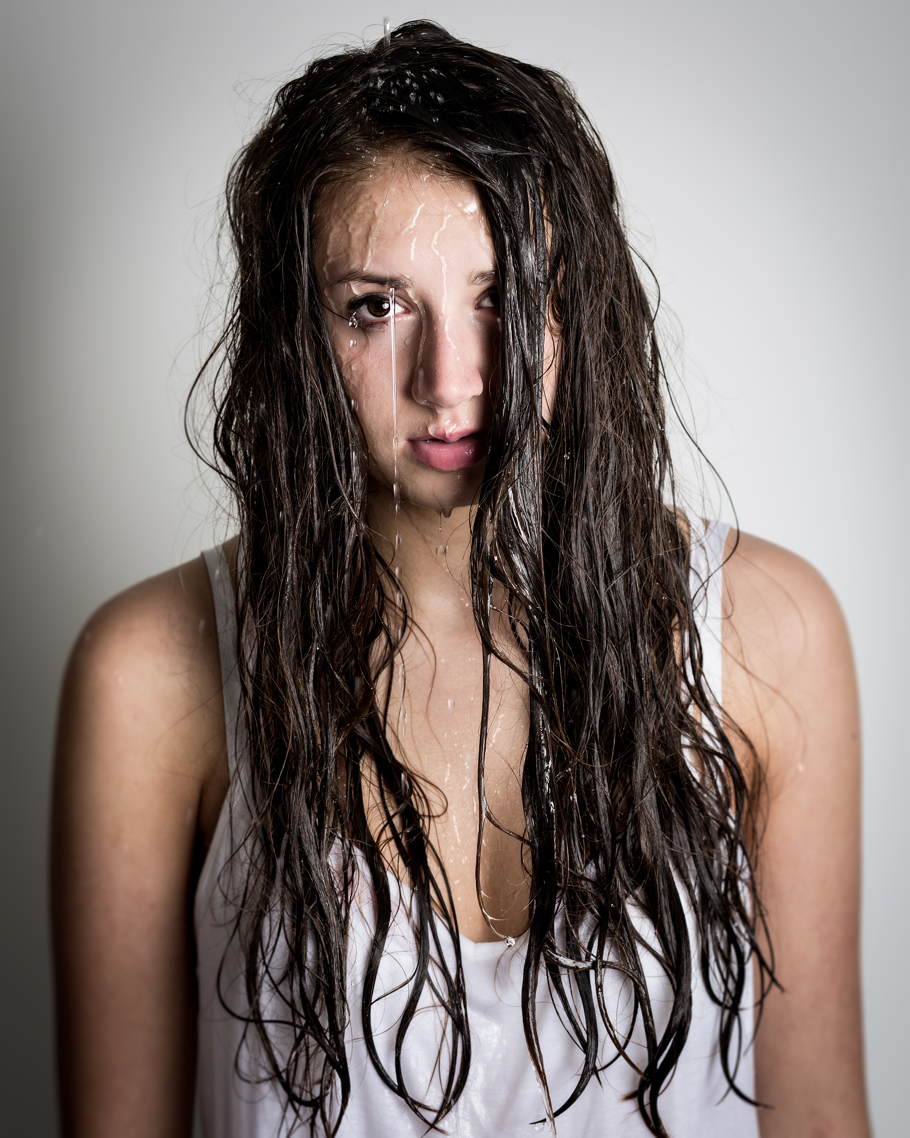Adolescente con agua cayéndole por la cara y el pelo | Fuente: Shutterstock.com