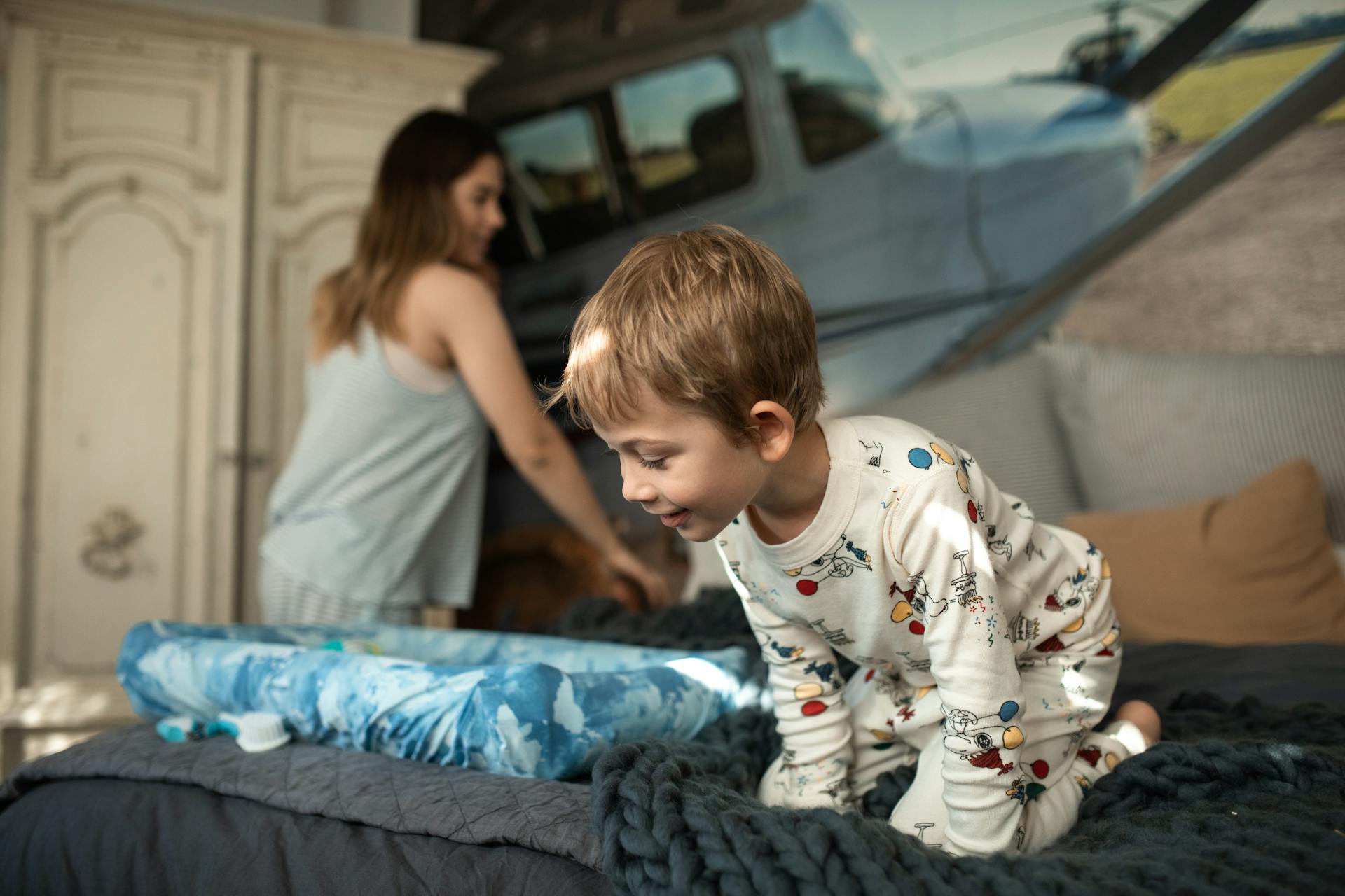 Un niño en pijama sobre la cama | Fuente: Pexels