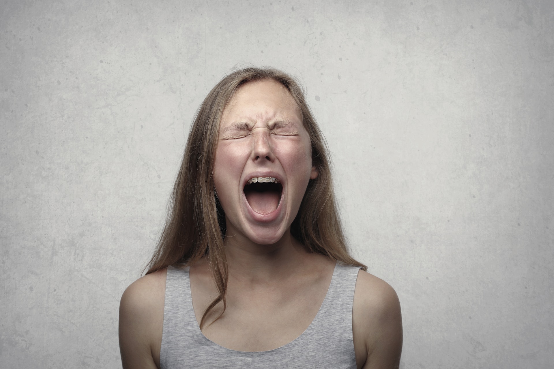 Una mujer gritando con los ojos cerrados | Fuente: Pexels