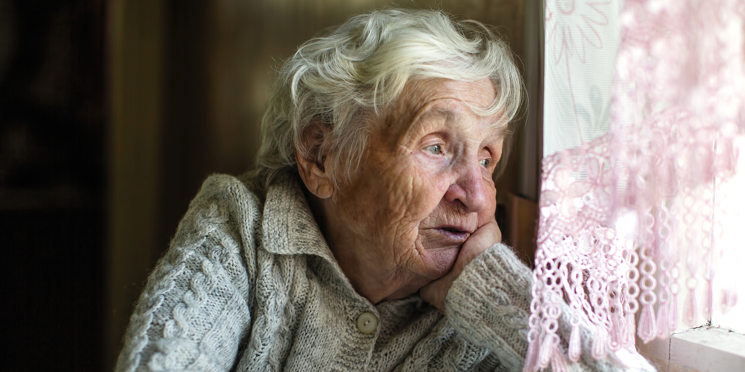 Una anciana triste mirando por la ventana | Fuente: Shutterstock