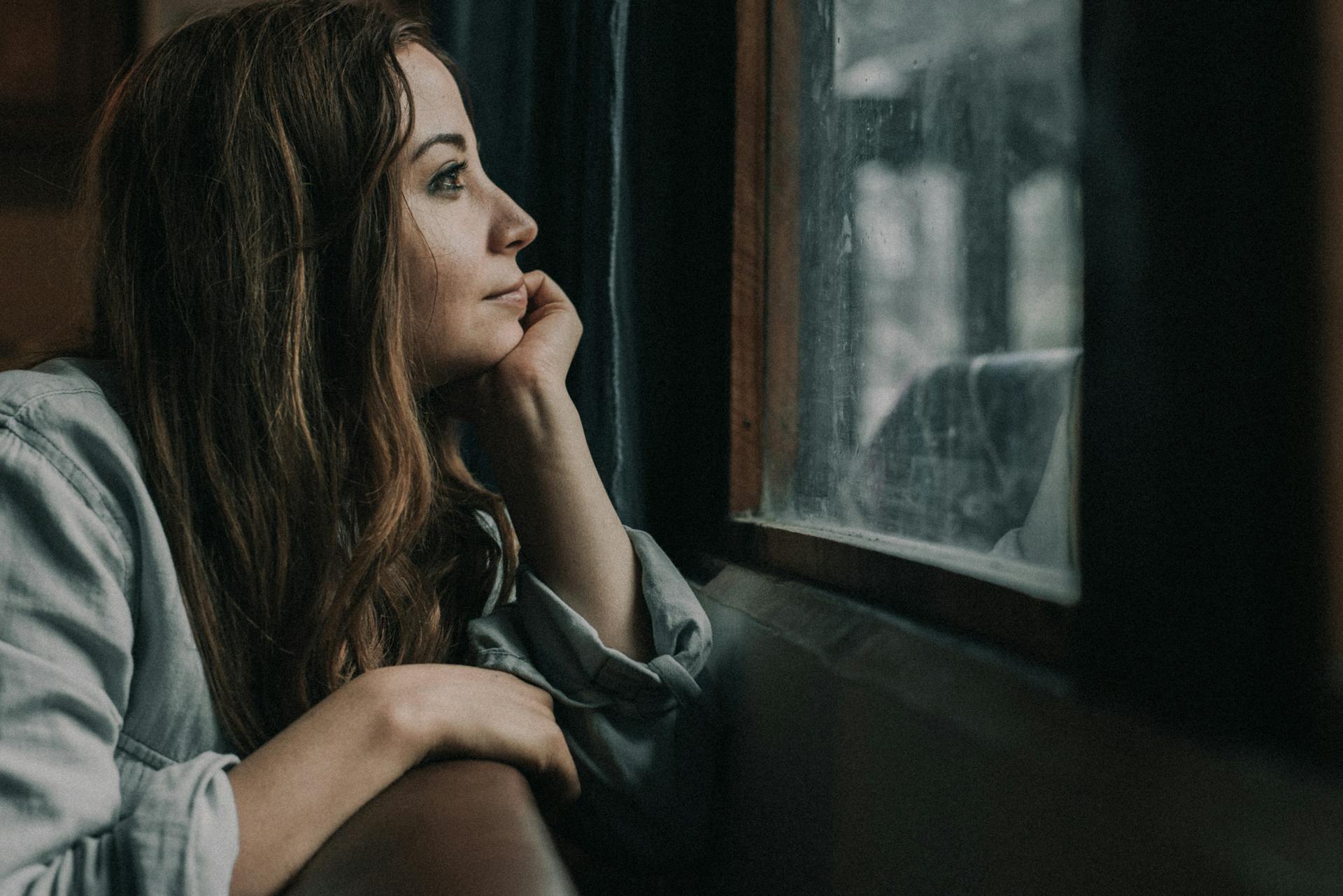Una mujer mirando por la ventana | Fuente: Pexels