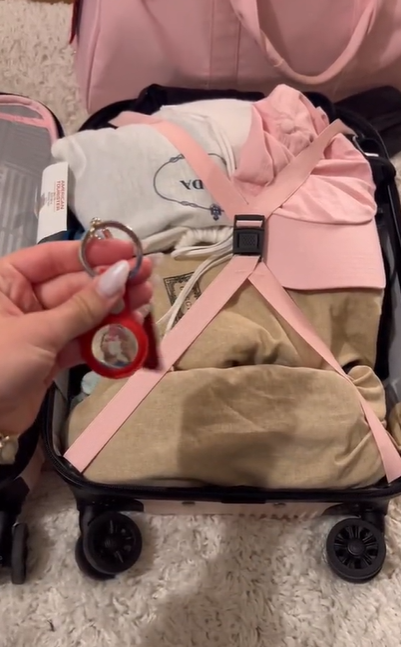 Katarina Mogus sostiene una Apple AirTag cerca de su bolsa de equipaje, según se ve en un vídeo del 27 de junio de 2022 | Fuente: TikTok/@katamogz