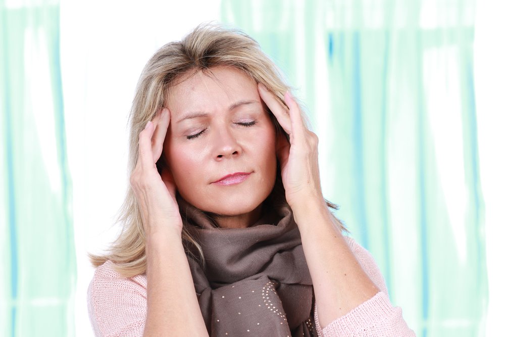 Mujer adolorida con migraña sostiene sus manos en la cabeza |Foto: Shutterstock