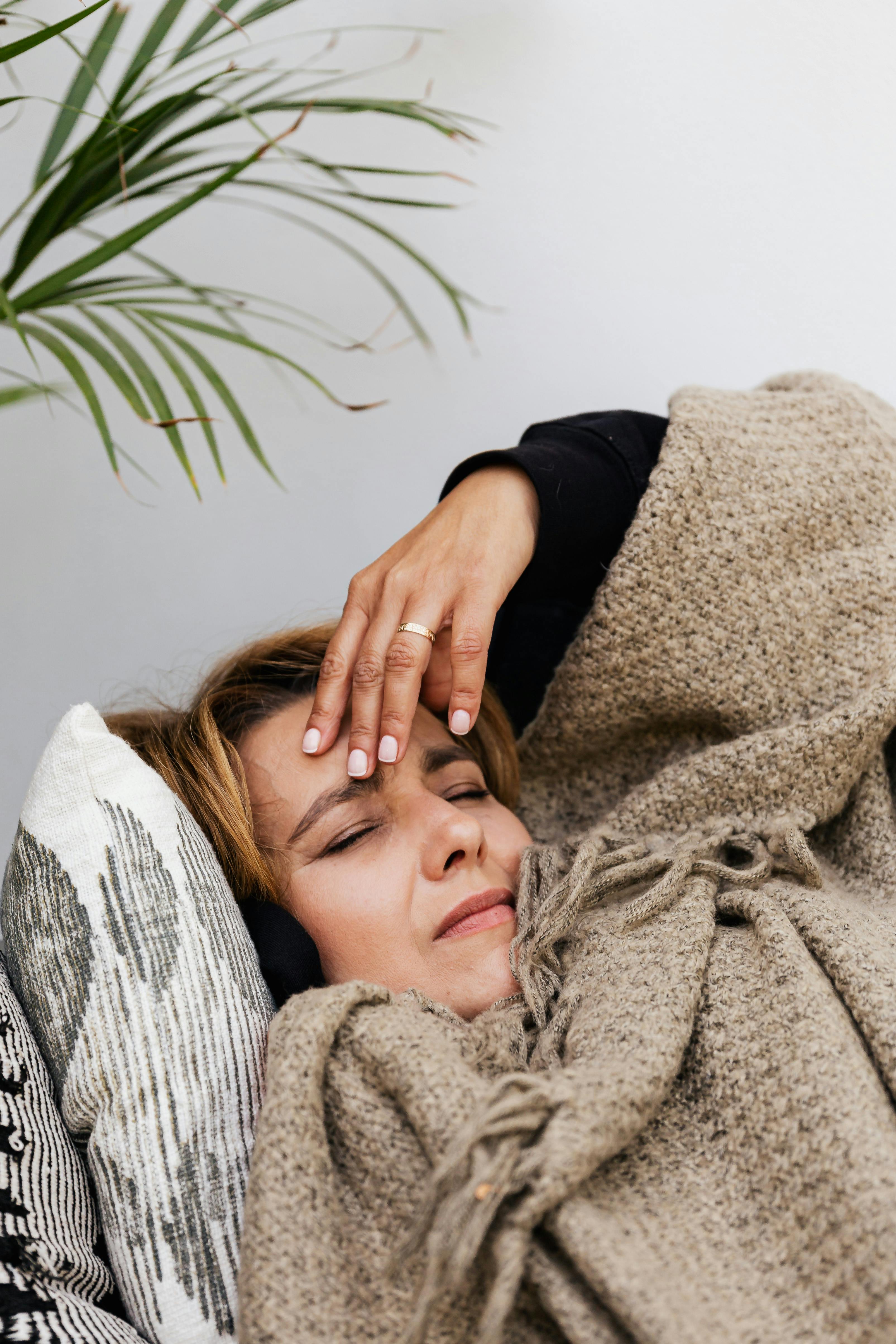 Una mujer con aspecto de enferma reclinada en la cama | Fuente: Pexels