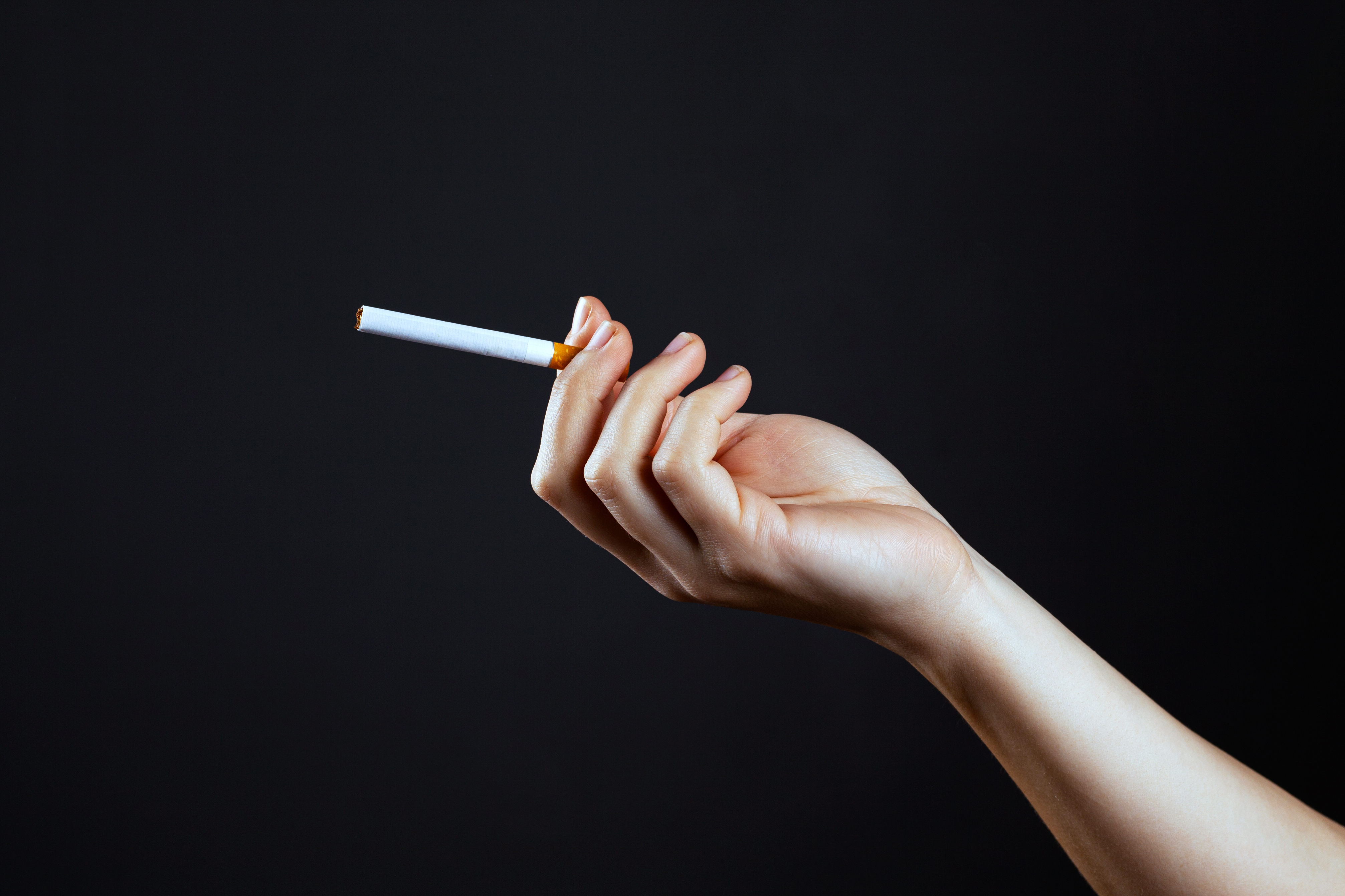 Mano femenina sujetando un cigarrillo | Fuente: Shutterstock