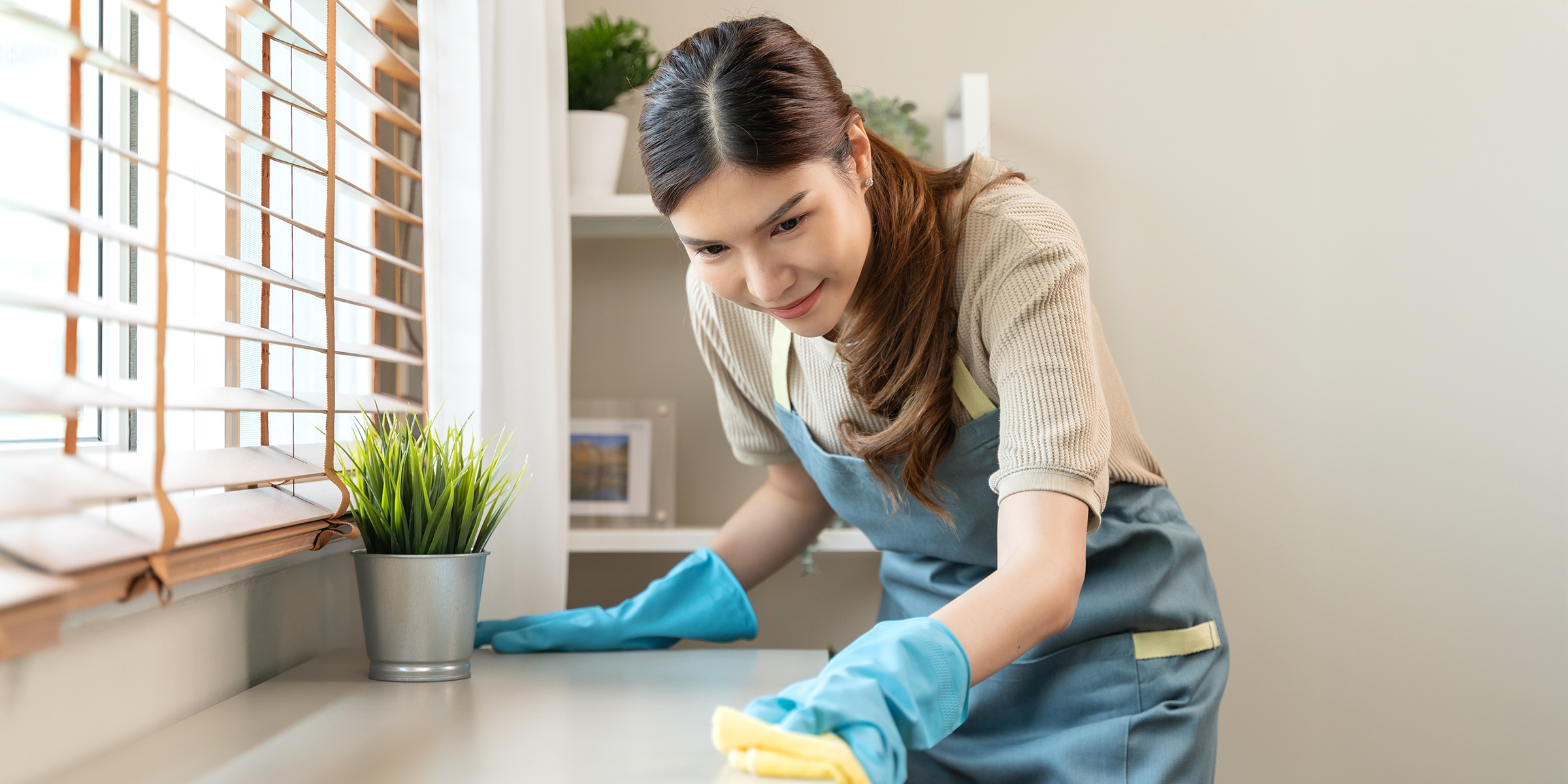 Una mujer limpiando una encimera | Fuente: Shutterstock