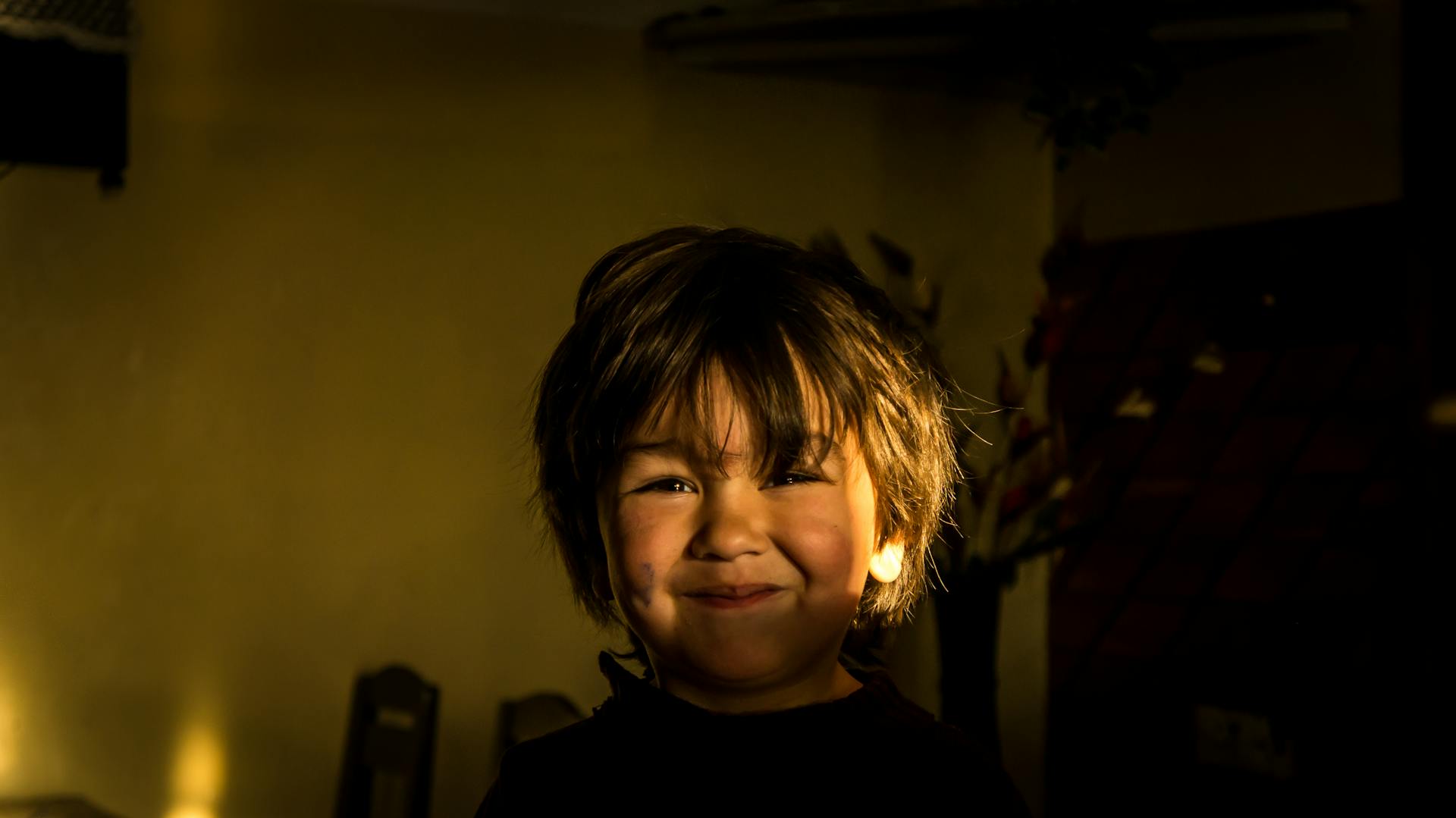 Un niño en una habitación a oscuras | Fuente: Pexels
