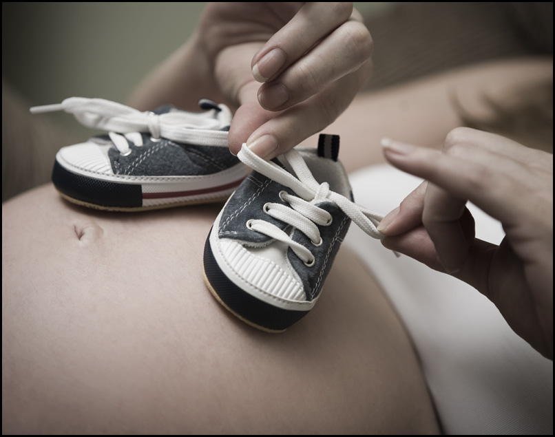 Zapatos de bebé sobre el vientre de una mujer embarazada | Foto: Flickr.com/Meagan (CC BY 2.0)