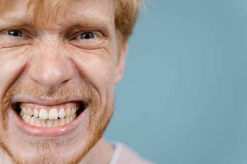 Hombre con una sonrisa maliciosa y desagradable. | Foto: Unsplash