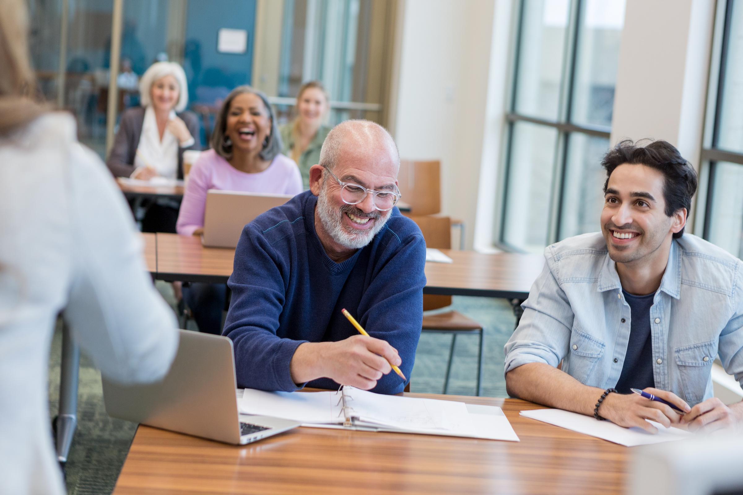 Un grupo de edades mixtas en un aula aprendiendo nuevas habilidades informáticas. | Fuente: Getty Images