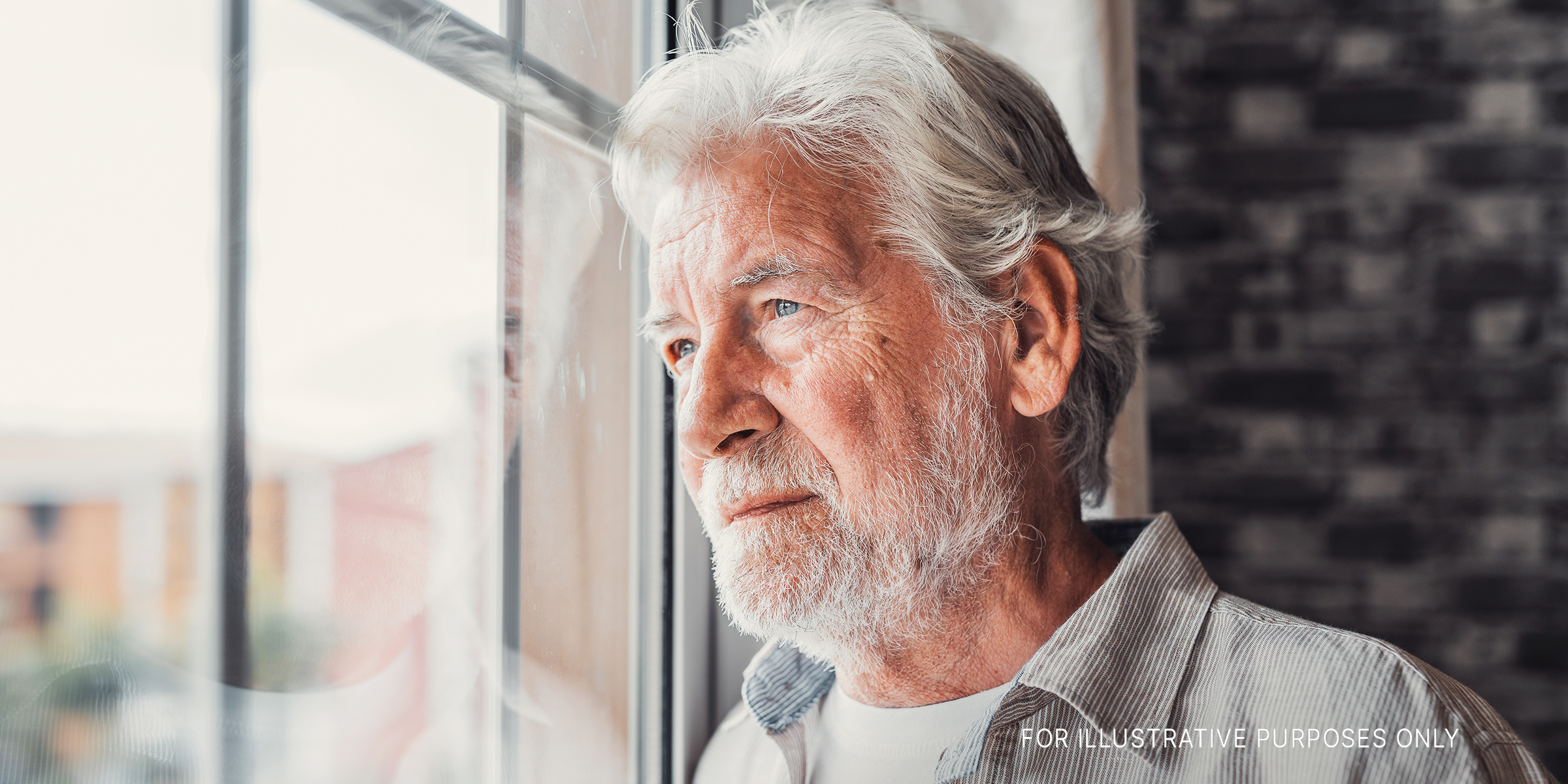 Un hombre mayor mirando por una ventana | Foto: Shutterstock
