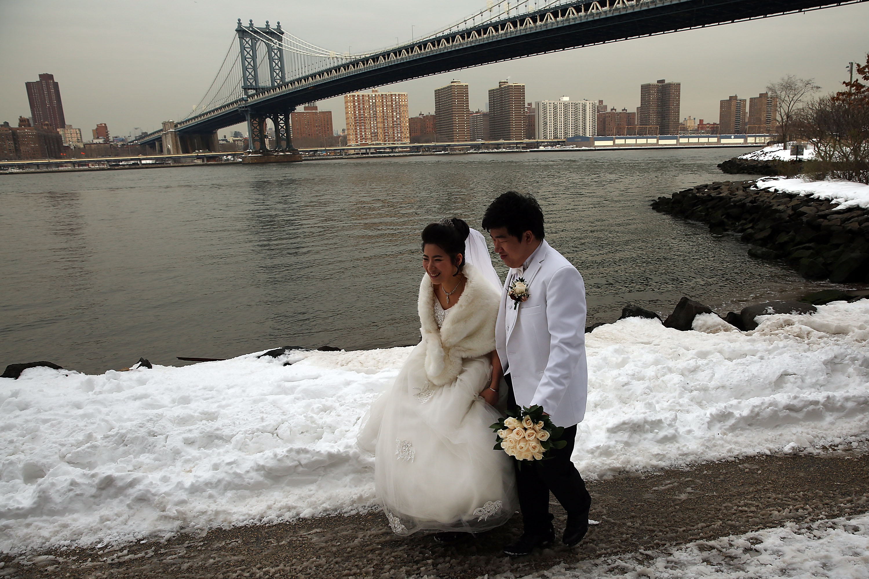 Una pareja de recién casados ​​camina en la nieve el primer día laboral después de una tormenta de nieve que estableció un nuevo récord de nevadas en un solo día en Nueva York. | Foto:Getty Images