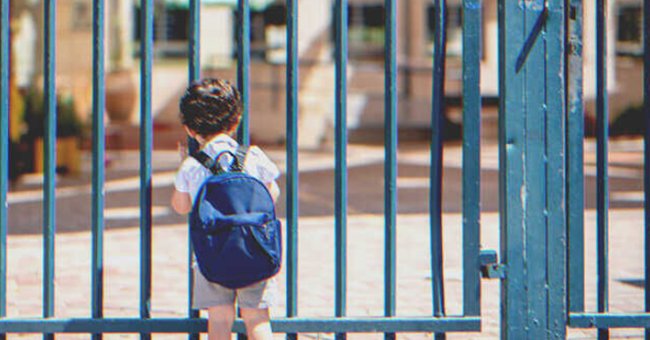 Un niño solo frente a unas rejas | Foto: Shutterstock