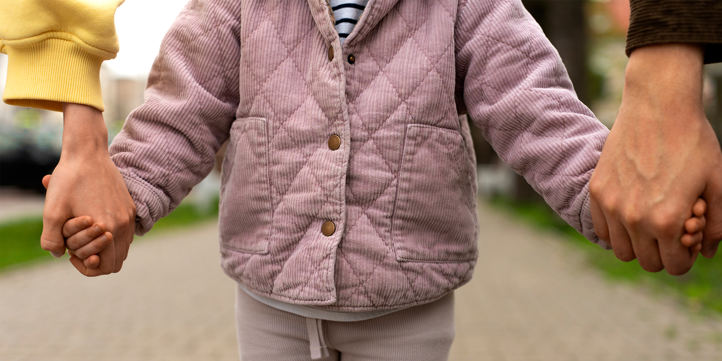 Un hombre y una mujer cogidos de la mano con una niña | Fuente: Freepik