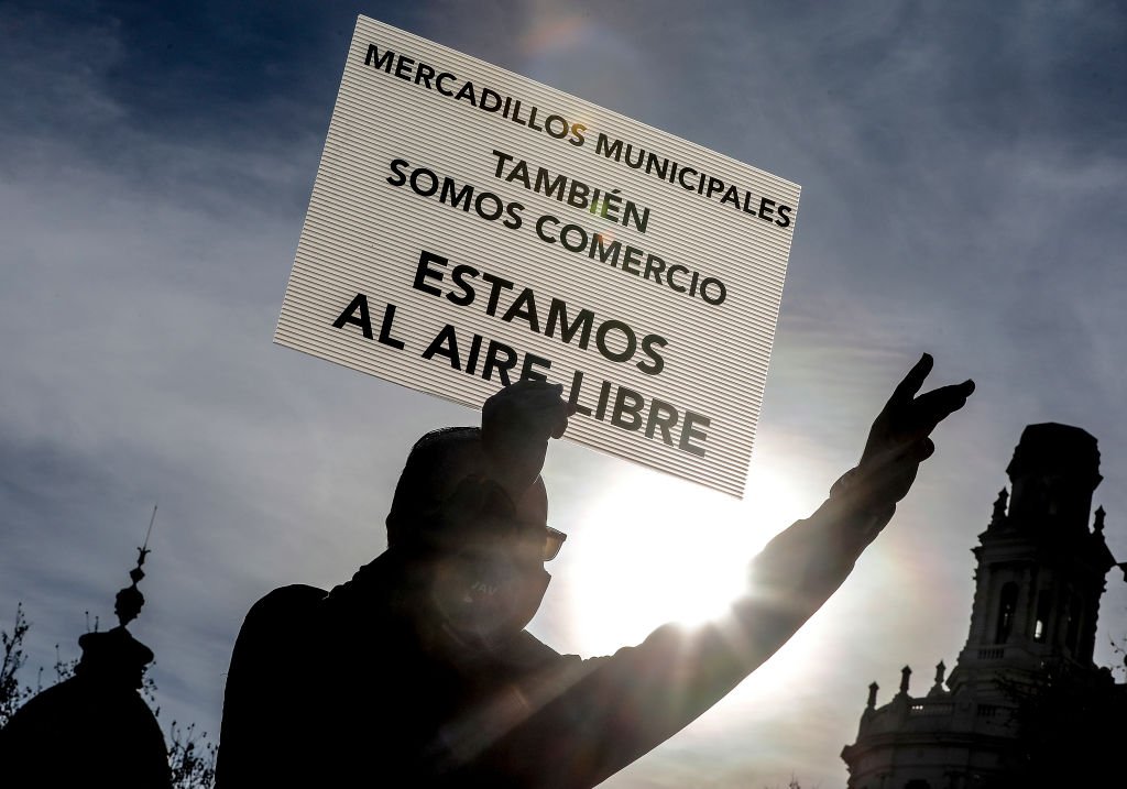 Hombre sostiene una pancarta durante una manifestación contra la suspensión de mercadillos en Valencia, España, enero 2021. | Foto: Getty Images