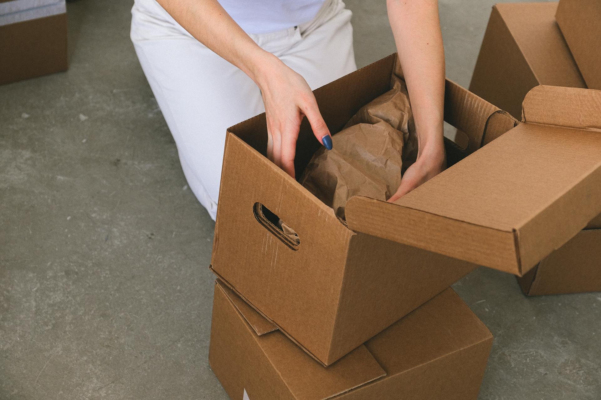 Una mujer ordenando cajas de cartón | Fuente: Pexels