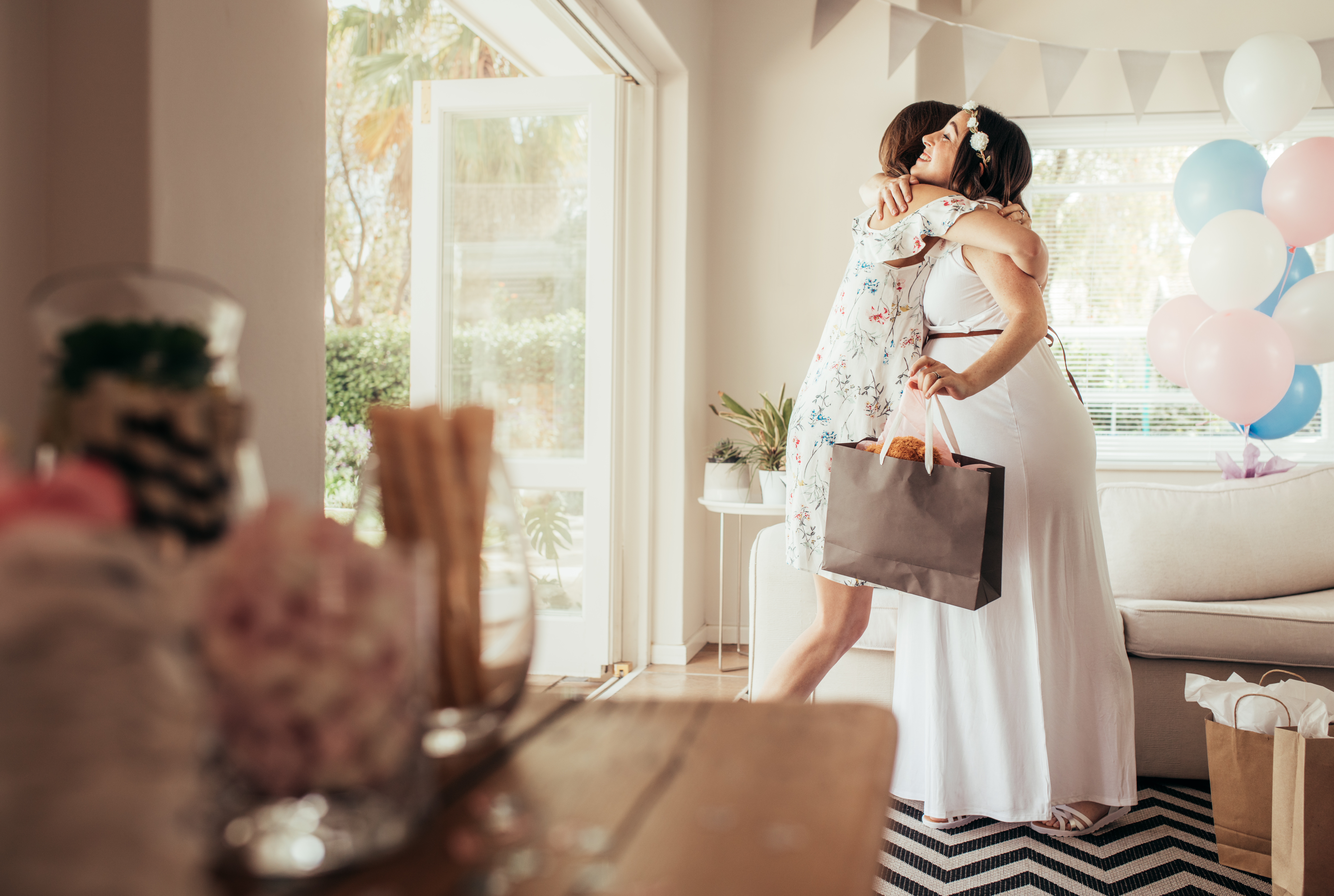 Una mujer abraza a una madre embarazada en un baby shower. | Foto: Shutterstock