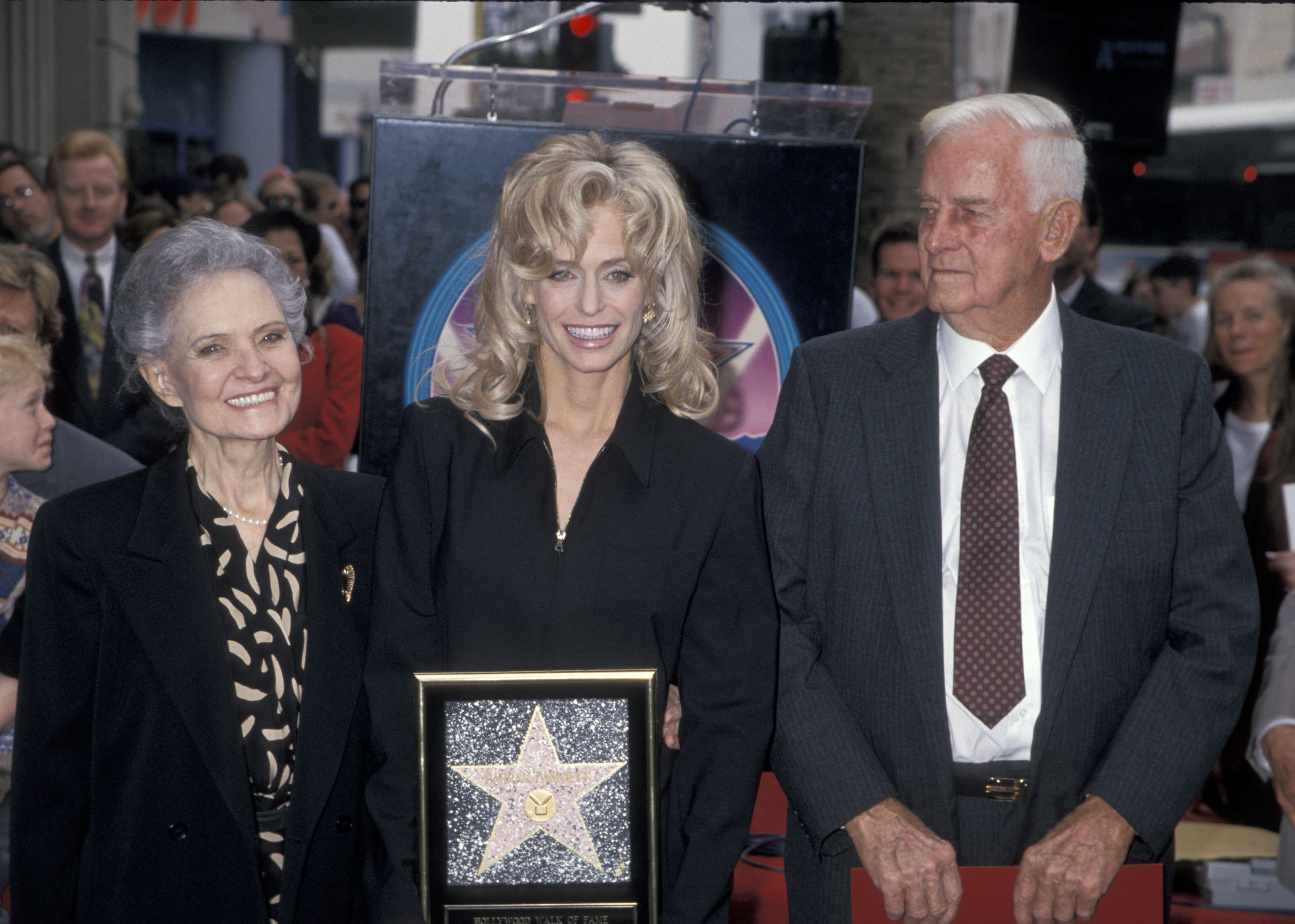 Farrah Fawcett con sus padres Pauline y James Fawcett mientras es honrada con una Estrella en el Paseo de la Fama de Hollywood, el 23 de febrero de 1995. | Foto: Getty Images