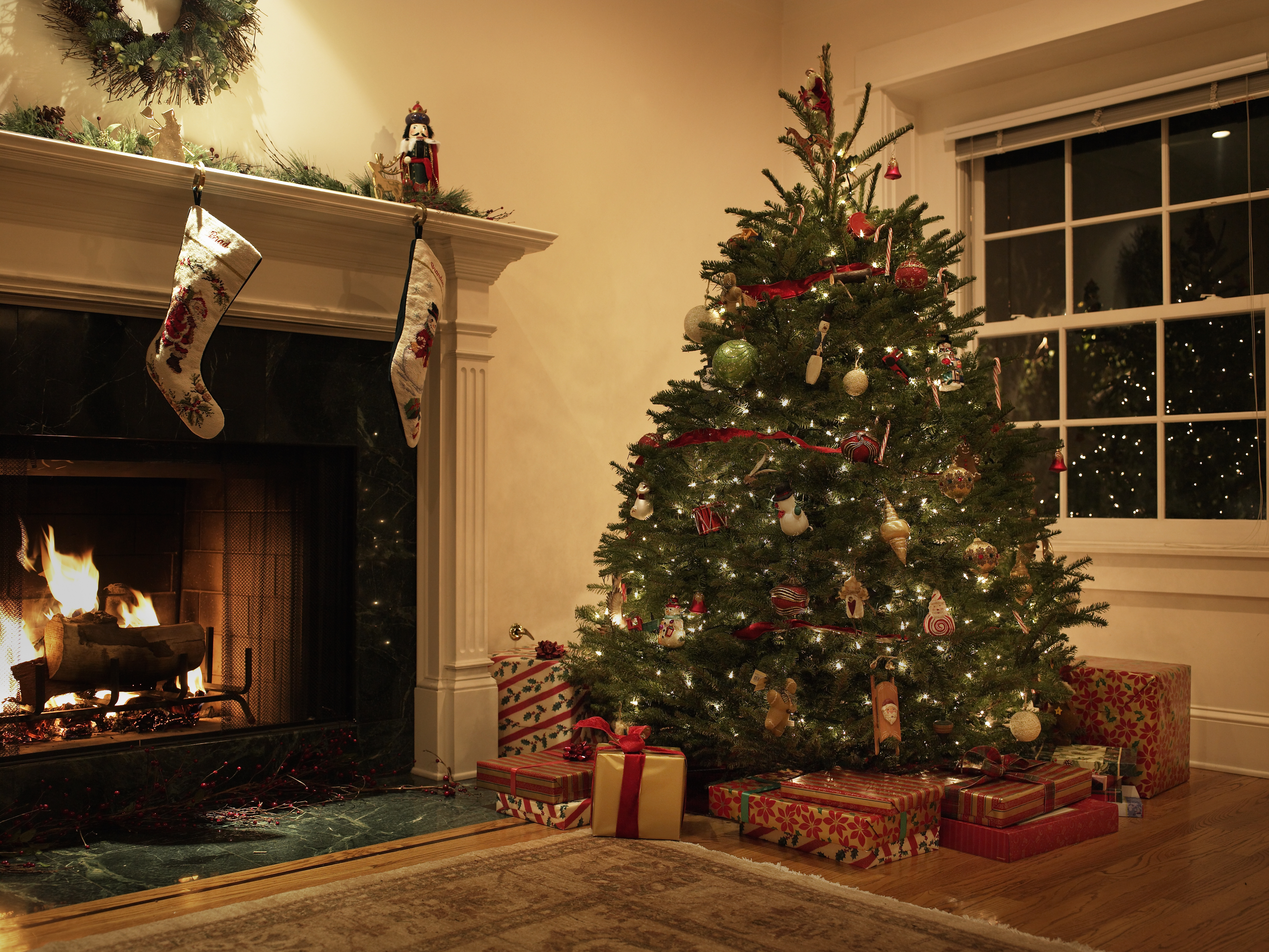 Un salón decorado con un árbol de Navidad y medias sobre la chimenea | Foto: Getty Images