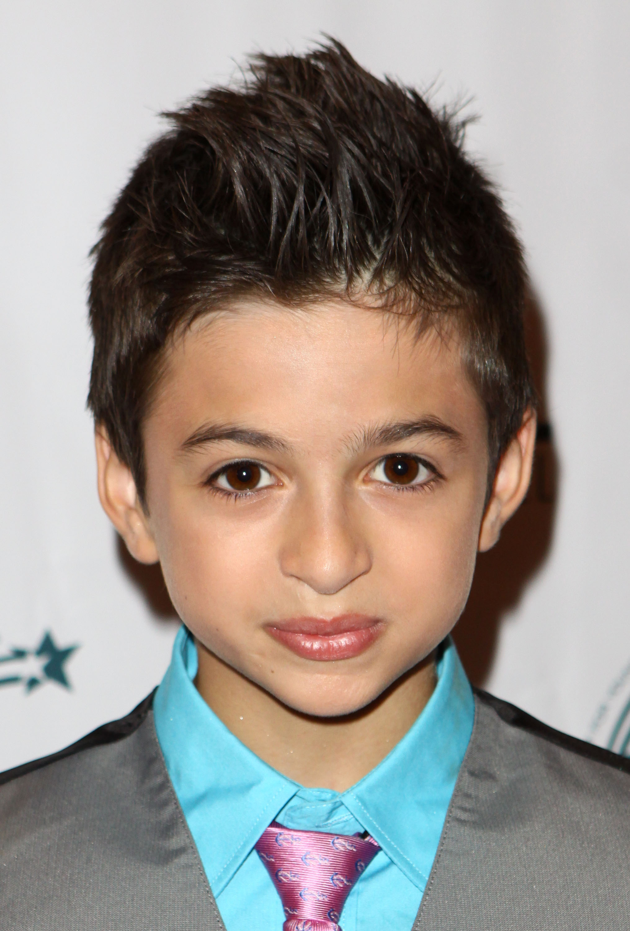 El joven actor asiste al "Brighton Hall Live" en el teatro El Portal de North Hollywood, California, vestido con una chaqueta gris, una camisa azul brillante y una corbata rosa estampada. | Fuente: Getty Images