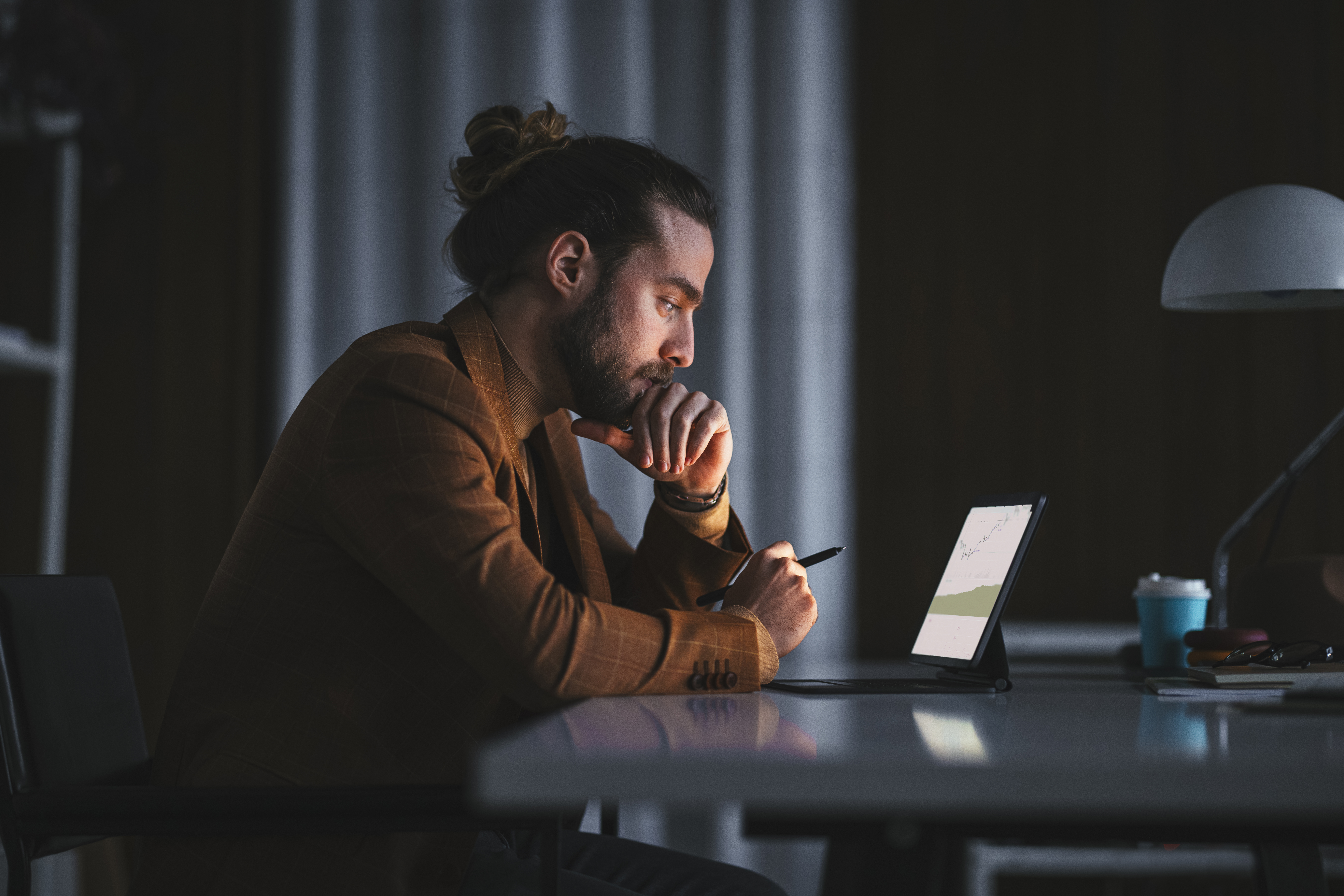 Hombre pensativo trabajando con un portátil en la oficina | Foto: Getty Images